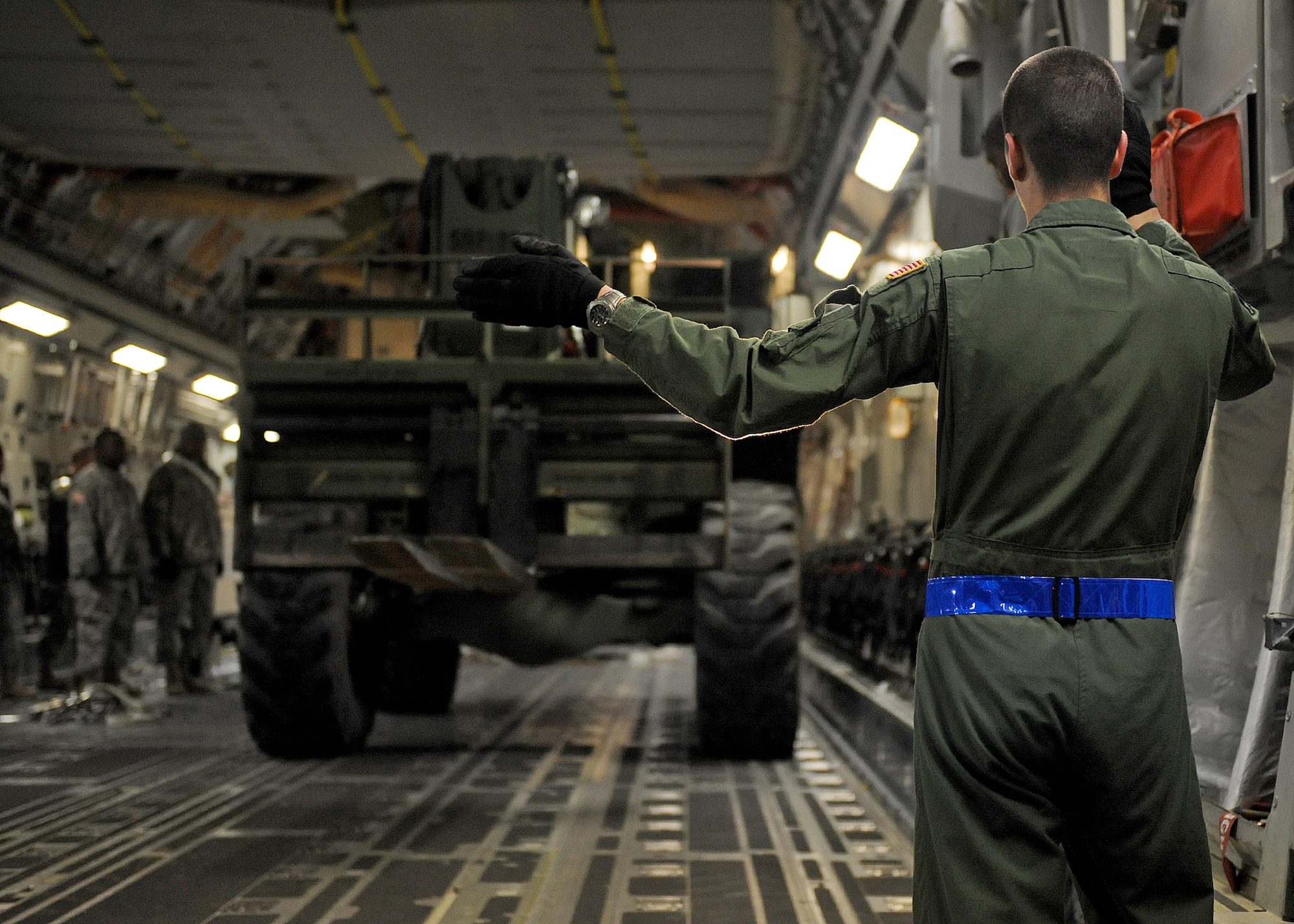 Airman 1st Class Alec Parker directs a vehicle into the bay of a C-17 Globemaster III Jan. 22, 2010, at Langley Air Force Base, Va., in support Operation Unified Response. Langley AFB Airmen and Army members from Fort Eustis, Va., helped McChord AFB, Wash., Airmen load equipment and supplies onto the aircraft. Airmen Parker is a 7th Airlift Squadron loadmaster from McChord Air Force Base, Wash. (U.S. Air Force photo/ Airman Rebecca Montez)