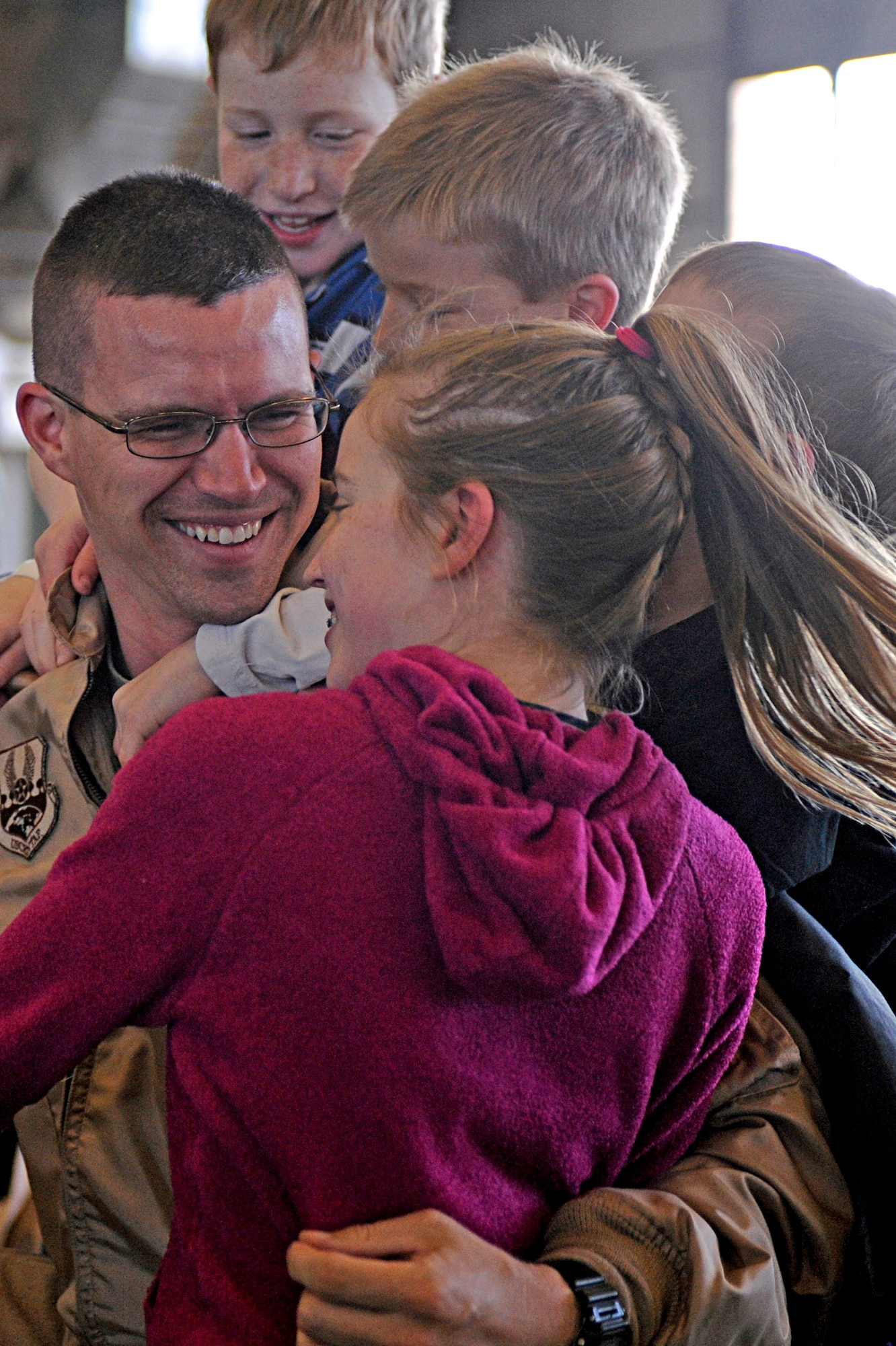 Capt. Louis Heidema is swarmed by his children after returning home from his deployment Jan. 27, 2010, at Ellsworth Air Force Base, S.D. While deployed, Captain Heidema provided support to operations Iraqi Freedom and Enduring Freedom. Captain Heidema is a 37th Bomb Squadron weapons systems officer. (U.S. Air Force photo/Airman 1st Class Matthew Flynn)