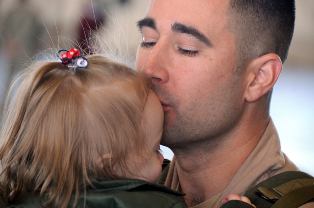 Maj. Nathan Rowman gives his daughter, Ellaa, a kiss Jan. 27, 2010, at Ellsworth Air Force Base, S.D. While deployed to Southwest Asia, Major Rowman provided support to operations Iraqi Freedom and Enduring Freedom. Major Rowman is a 37th Bomb Squadron B-1B Lancer pilot. (U.S. Air Force photo/Senior Airman Adam Grant)