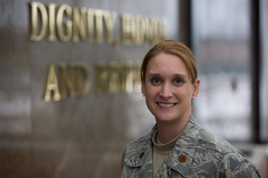Maj. Shannon Mann, chief of public affairs for the 916th Air Refueling Wing, stands in the atrium at the Air Force Mortuary Affairs Operations Center in front of the center's mantra 'dignity, honor and respect.' Maj. Mann deployed to AFMAO to support media access to witness the dignified transfers of U.S. military war fallen. (USAF photo by TSgt. Gareth Buckland, AFMAO/PA)
