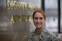 Maj. Shannon Mann, chief of public affairs for the 916th Air Refueling Wing, stands in the atrium at the Air Force Mortuary Affairs Operations Center in front of the center's mantra 'dignity, honor and respect.' Maj. Mann deployed to AFMAO to support media access to witness the dignified transfers of U.S. military war fallen. (USAF photo by TSgt. Gareth Buckland, AFMAO/PA)