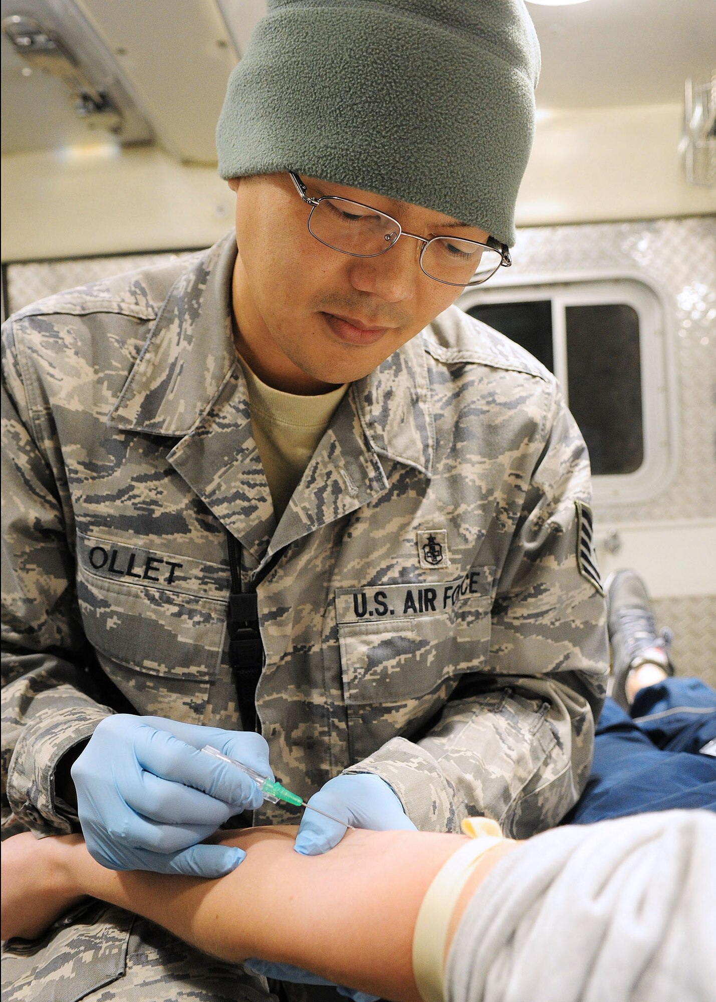 Tech. Sgt. Lemuel Ollet demonstrates how to put an IV in a patient's arm in the back of an ambulance Feb. 1, 2010, at the Transit Center at Manas, Kyrgyzstan. Sergeant Ollet was on duty Jan. 18, 2010 when Jamie Morris, a Peace Corps volunteer in Central Asia, was transported to the Transit Center for medical treatment after an automobile accident. Sergeant Ollet is a 376th Expeditionary Medical Group aero medical technician. (U.S. Air Force photo/Senior Airman Nichelle Anderson)
