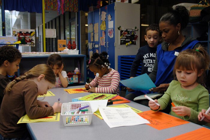 A group of children color and design valentines at the Child Development Center here Feb. 2. The valentines which bear simple Valentine's Day greetings in French are planned to be offered to Haiti evacuees aboard C-17s flying around-the-clock missions from Joint Base Charleston. (U.S. Air Force Photo/Airman 1st Class Lauren Main)