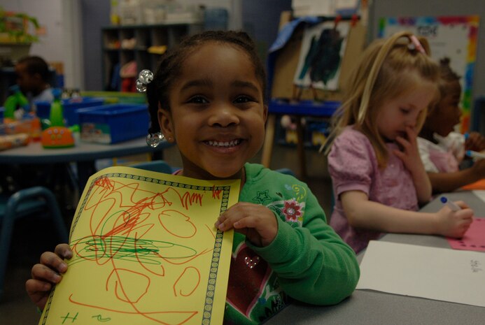 Katelyn Tharpe proudly displays her valentine she colored at the Child Development Center here Feb. 2. The valentines are planned to be offered to Haitian evacuees aboard C-17s flying around-the-clock missions from Joint Base Charleston. Katelyn is the daughter of Staff Sgt. Kenyetta Tharpe who is an Air Force Liason with the Naval Consolidated Brig. (U.S. Air Force Photo/Airman 1st Class Lauren Main)