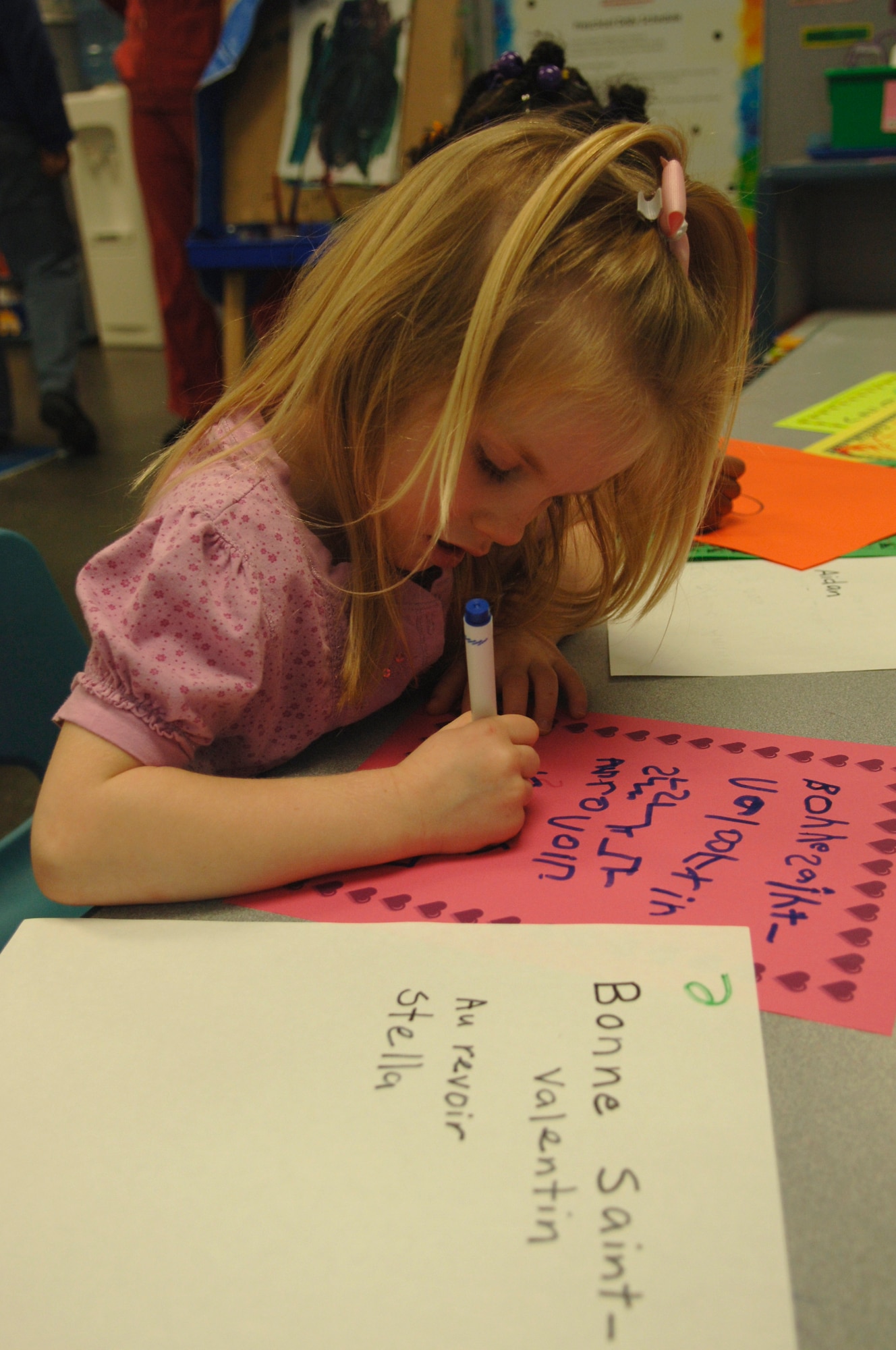 Stella Montgomery works diligently while copying a French phrase onto her Valentine at the Child Development Center here, Feb. 2. Once completed, the Valentines will be shipped to Haiti aboard the C-17's flying around the clock missions and delivered by the aircrew aboard. The Valentines read simple greetings that translate to, "Happy Valentines Day. Goodbye, Stella". Stella is the daughter of Airman 1st Class Jeffrey Montgomery who is an Air Transportation Apprentice with the 437th Aerial Port Squadron. (U.S. Air Force Photo/ Airman 1st Class Lauren Main)