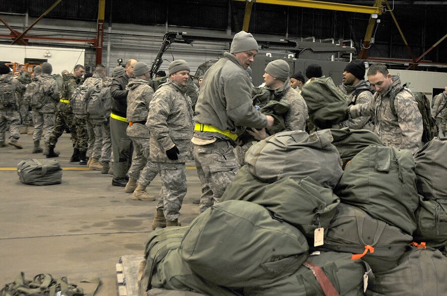SCOTT AIR FORCE BASE, Ill. – Scott team members off-load mobility bags from a pallet in hangar 1 at Scott AFB January 27, 2010. The Scott members picked up their bags and were released home after returning from an Operational Readiness Exercise at Volk Field Combat Readiness and Training Center, Wis. The ORE was to help prepare Scott Airmen for the upcoming Operational Readiness Inspection in late March. (U.S. Air Force photo by Staff Sgt. Brian J. Ellis)