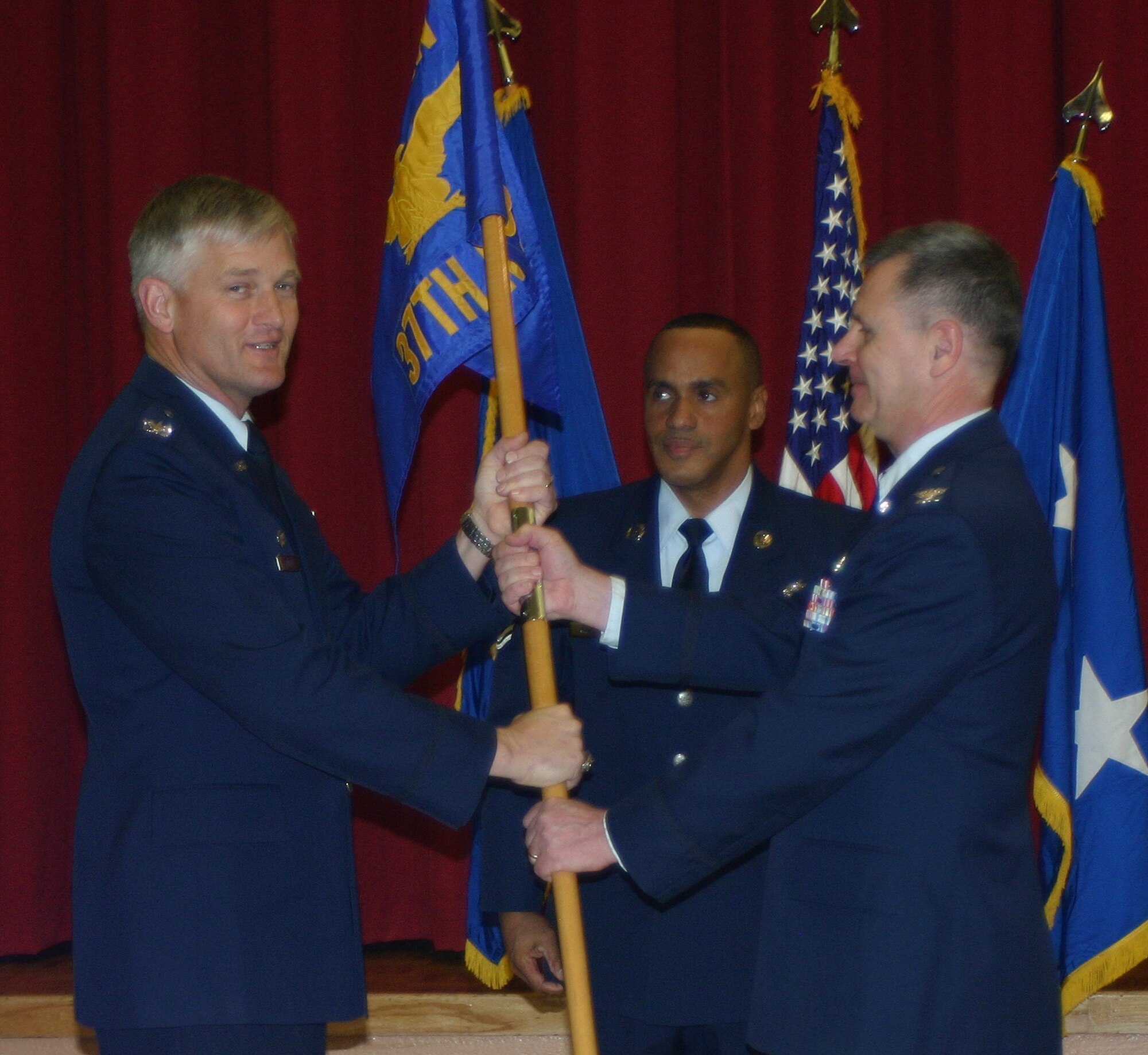 Col. William Mott, 37th Training Wing commander (left), takes the 37th Medical Group guidon from its commander, Col.l (Dr.) Rick L. Campise, during a ceremony at Lackland Air Force Base, Texas, Feb. 1, where the medical group was inactivated. The group was immediately activated as the 559th MDG under the 59th Medical Wing. (U.S. photo by Sue Campbell)