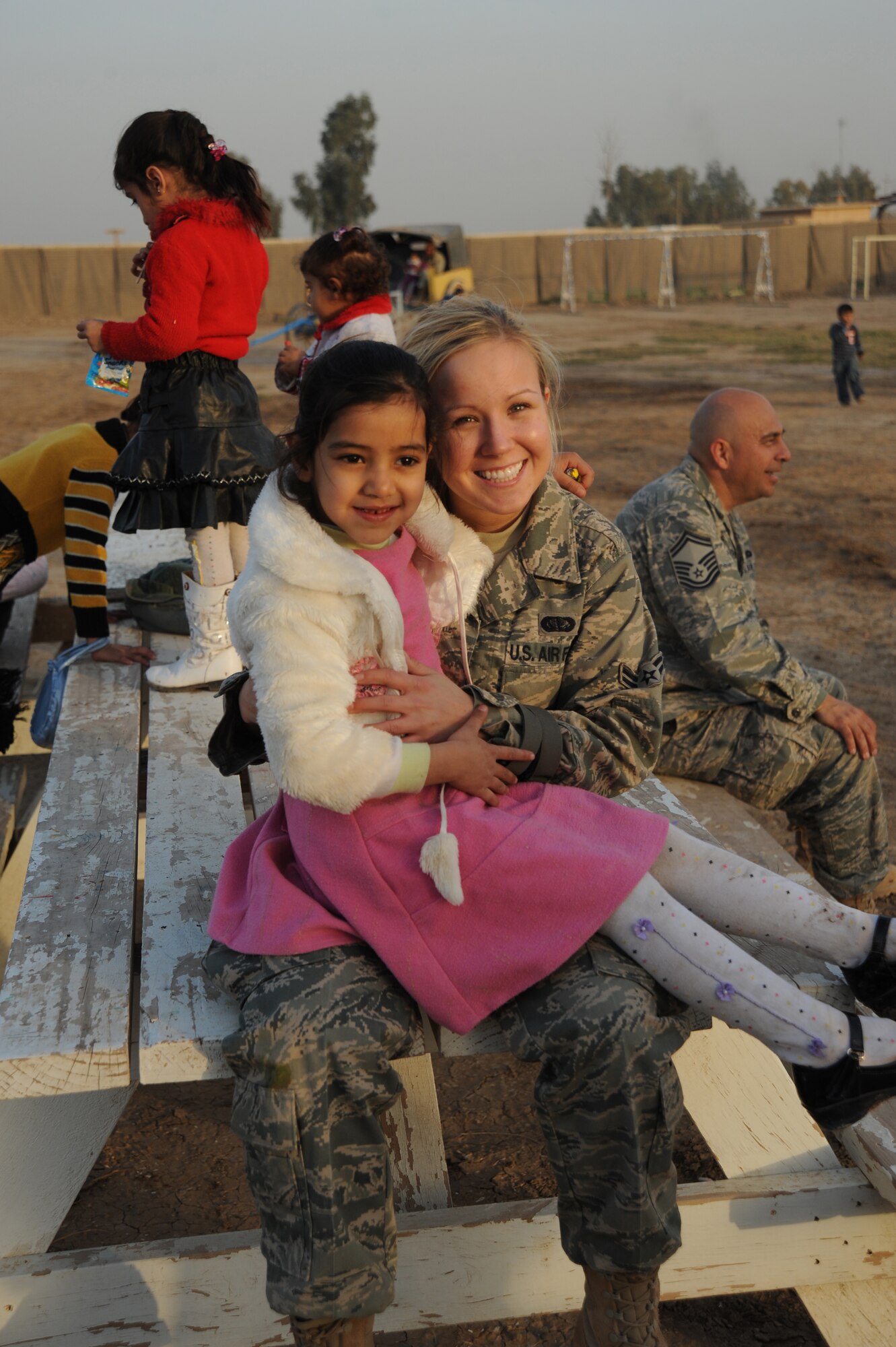 Airman 1st Class Brittany Sias, 447th Expeditionary Force Support Squadron, sits with an Iraqi girl while volunteering with the Good Neighbor Program Jan. 29, 2010. The GNP collects donated items such as toys, clothes, games, school supplies, and other needed items for distribution throughout the Iraqi community.(U.S. Air Force photo/ Senior Airman Eric Summers Jr/ released)