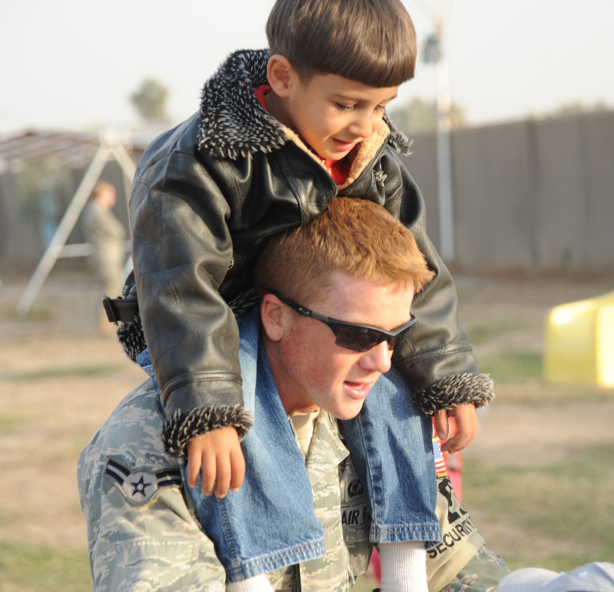 Airman 1st Class Shane Appleton, 447th Expeditionary Civil Engineer Squadron, gives a piggy-back ride to an Iraqi boy while volunteering with the Good Neighbor Program Jan. 29, 2010. The GNP collects donated items such as toys, clothes, games, school supplies, and other needed items for distribution throughout the Iraqi community. (U.S. Air Force photo/ Senior Airman Eric Summers Jr/ released)