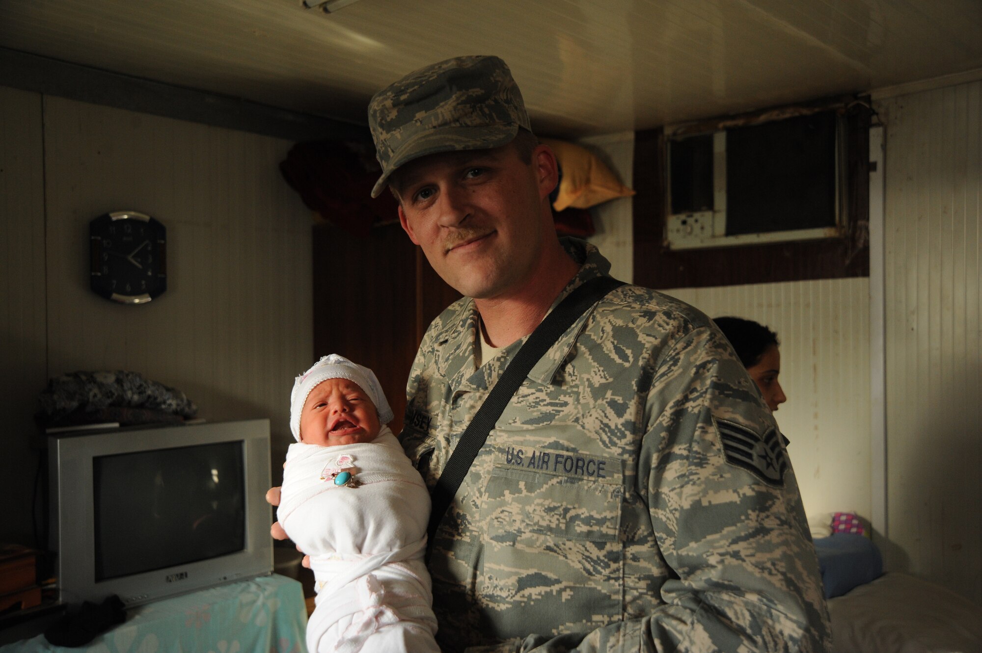 Staff Sgt. Richard Ramsey, 447th Expeditionary Logistics Readiness Group and Rising Six Good Neighbor Program coordinator, is asked to hold an Iraqi baby while distributing donations with the Good Neighbor Program Jan. 29, 2010. The GNP collects donated items such as toys, clothes, games, school supplies, and other needed items for distribution throughout the Iraqi community. (U.S. Air Force photo/ Senior Airman Eric Summers Jr/ released) 