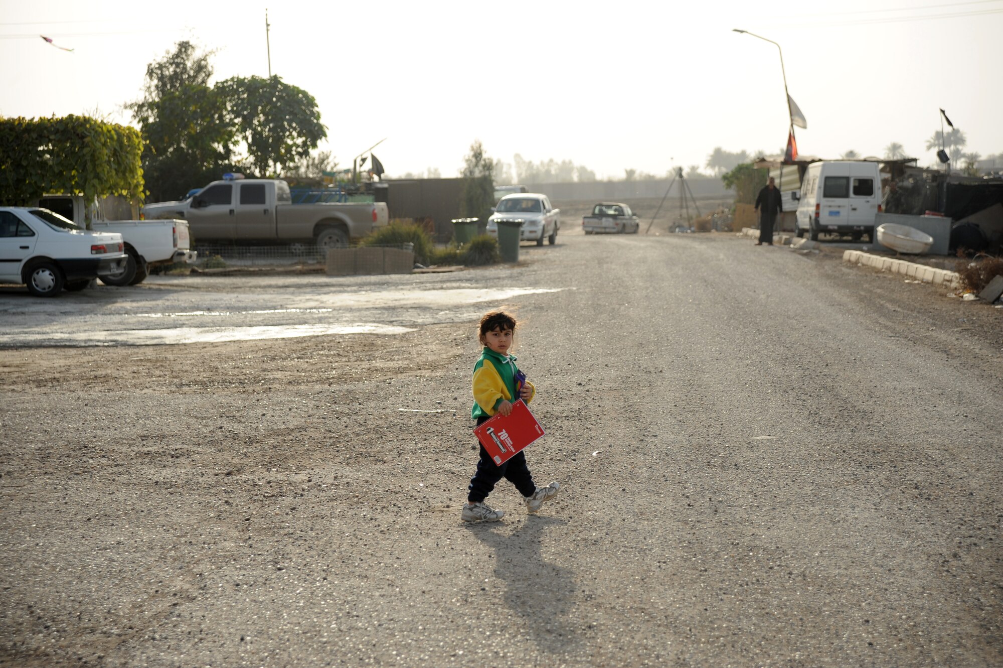 An Iraqi girl walks home after reciving paper and markers donted from the Good Neighbor Program Jan. 29, 2010. The GNP collects donated items such as toys, clothes, games, school supplies, and other needed items for distribution throughout the Iraqi community.  (U.S. Air Force photo/ Senior Airman Eric Summers Jr/ released)
