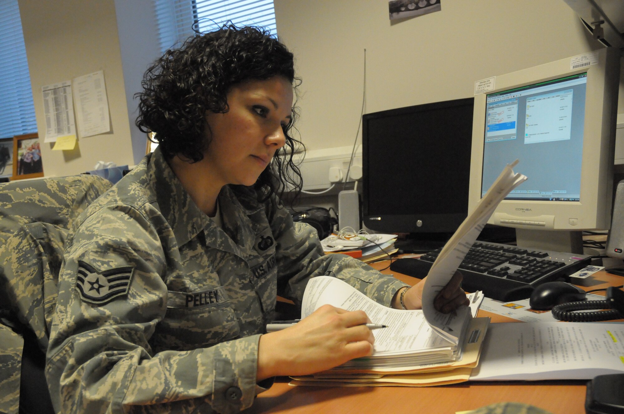 Staff Sgt. Heather Pelley, 48th Contracting Squadron contract specialist, , checks over paperwork at her desk in the Liberty Center at RAF Lakenheath, England, Feb. 2.  She was nominated for the Liberty Spotlight by her chain of command because she portrays the Air Force core value of "Service Before Self." 