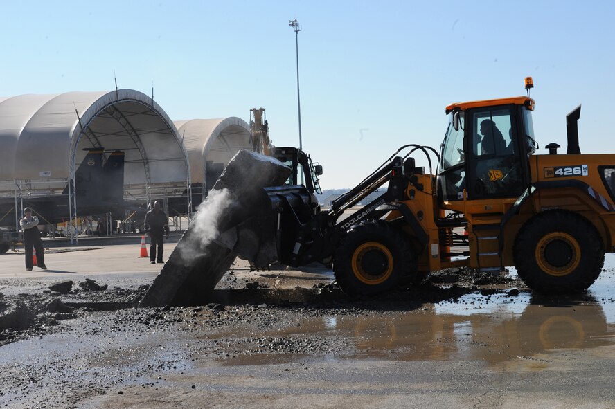 Malcolm Wright, 4th Civil Engineer Squadron equipment operator, uses a front-end loader to lift a slab of concrete on Seymour Johnson Air Force Base, N.C., Jan. 13, 2010. Due to a 10-inch water main break, several 20-inch thick concrete slabs were removed to locate the leak. Wright is from upstate New York.  (U.S. Air Force photo by Master Sgt. Brandt Smith)