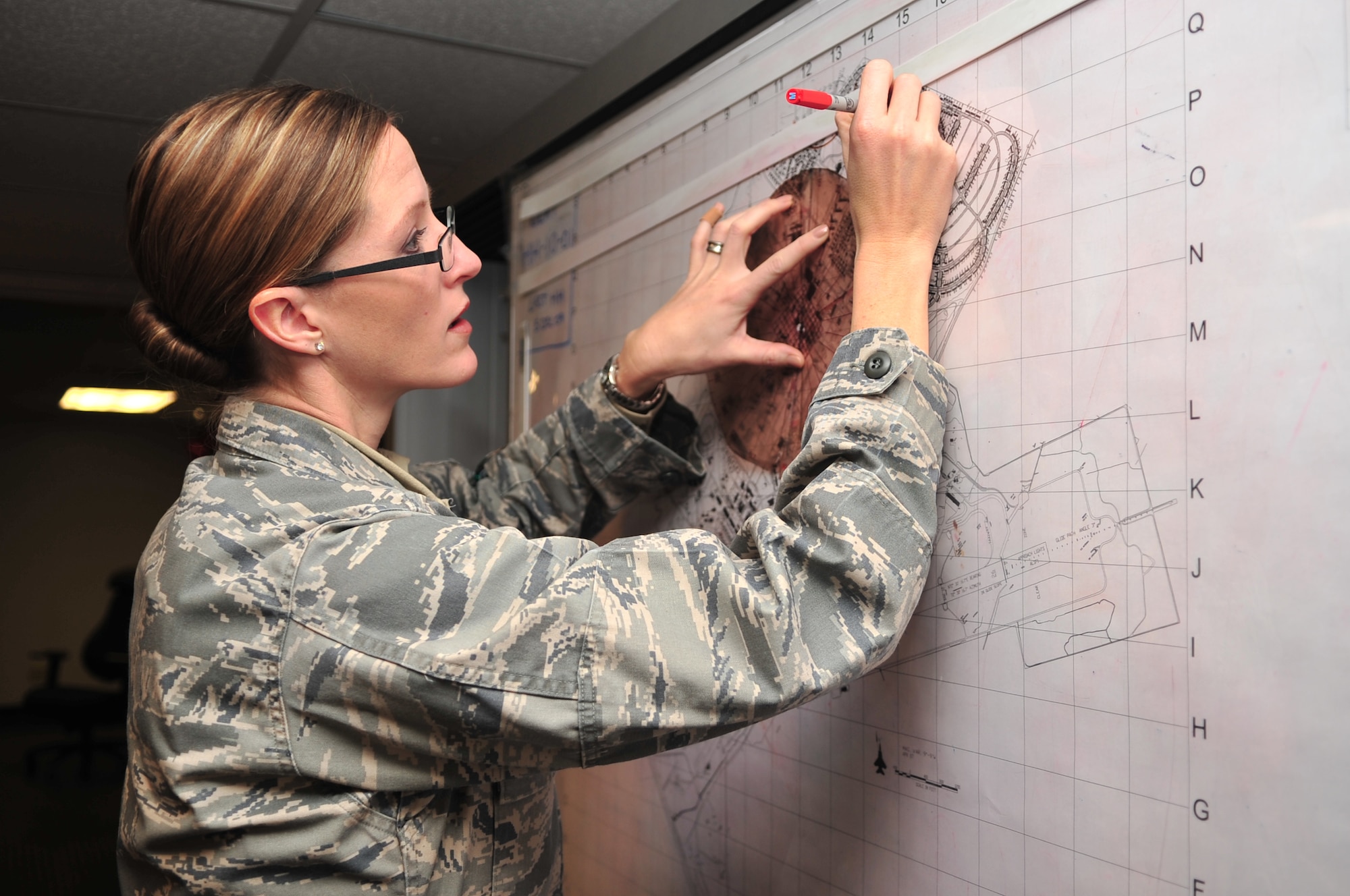 Second Lt. Kimberly Guest, 4th Security Forces Squadron flight commander, plots a point on a map at Seymour Johnson Air Force Base, N.C., Jan. 19, 2010. Members of the SFS are responsible for providing security and protection of base personnel and resources.  Lieutenant Guest is a native of Tampa, Fla. (U.S. Air Force photo/Airman 1st Class Rae Perry)