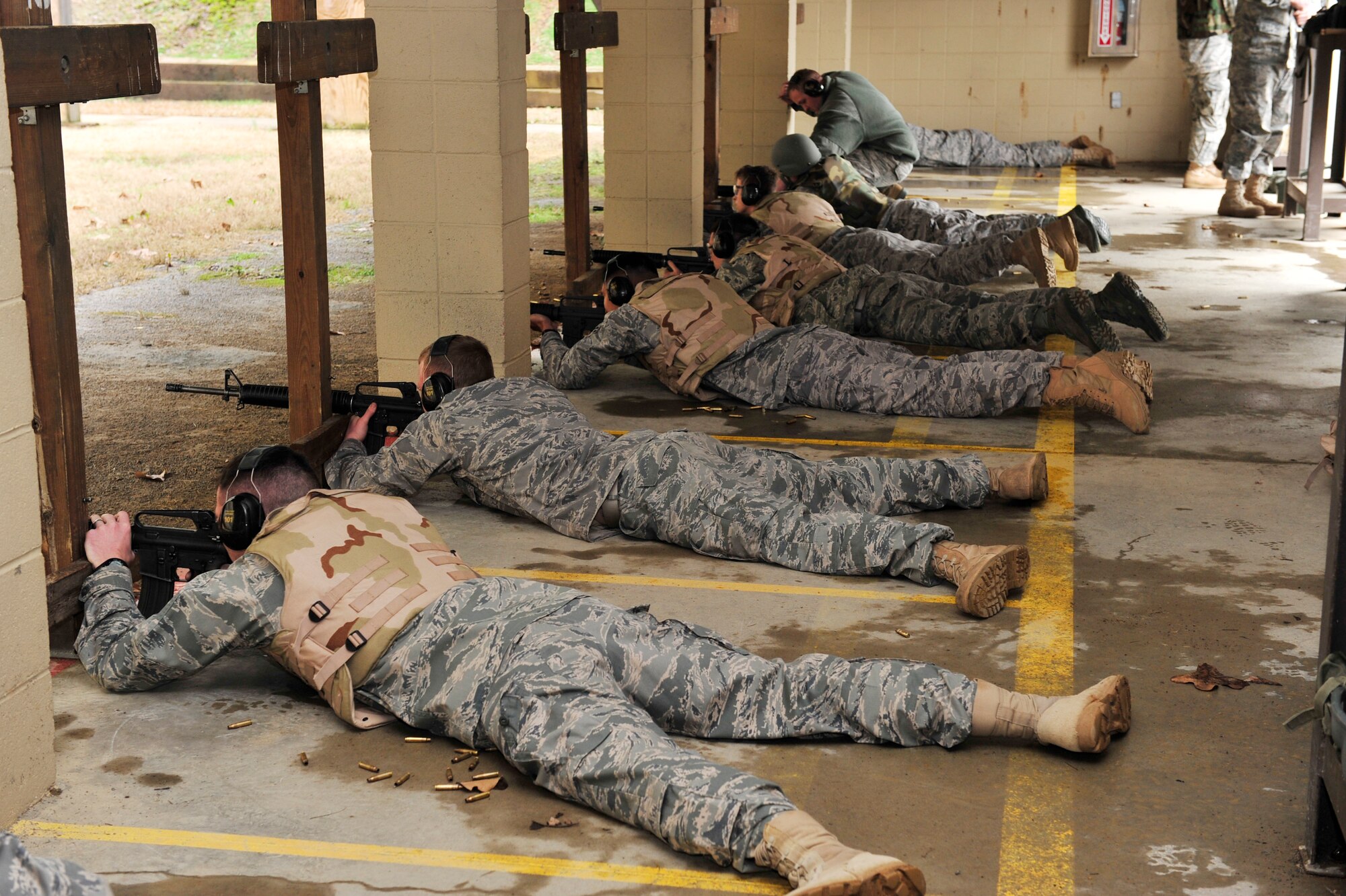 Students lie in the prone-supported position in preparation of firing M-16A2 rifles Jan 21. They must fire from five 5 different positions for qualification: prone-supported, prone-unsupported, prone-supported with gas mask, kneeling and over barricade. (U.S. Air Force photo by Airman 1st Class Lausanne Pacheco)