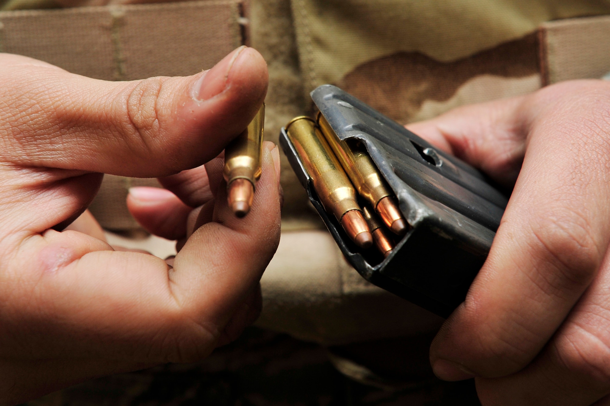 A student loads a magazine during the live-firing portion of a Combat Arms Training and Maintenance class on base Jan 21. The M-16A2 fires 5.56 mm semi-jacketed frangible rounds and each magazine holds up to 30 rounds. (U.S. Air Force photo by Airman 1st Class Lausanne Pacheco) 