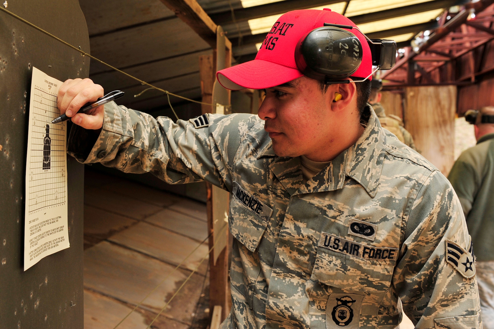 Senior Airman Victor McKenzie, 19th Security Forces Squadron combat arms instructor, makes sight corrections on a zero target on the firing range Jan 21. During site correcting, instructors brief students on fundamentals of weapons firing. (U.S. Air Force photo by Airman 1st Class Lausanne Pacheco)
