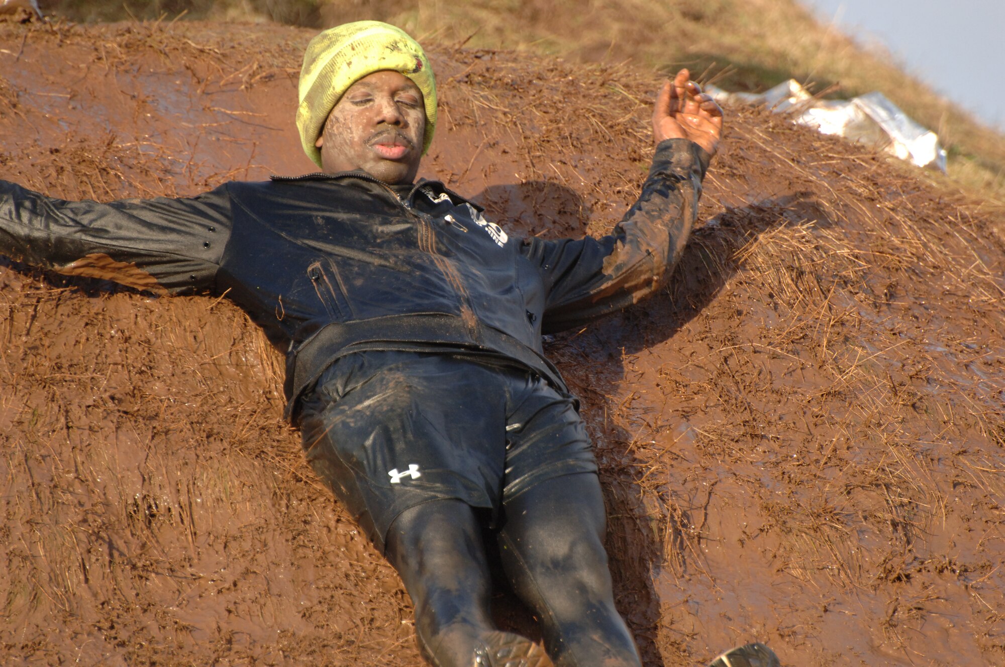 United States Navy Petty Officer 2nd Class Orville Hentley taking on the mudslide during the Tough Guy Challenge near Birmingham, England.  (Photo by Bridget Cruz)