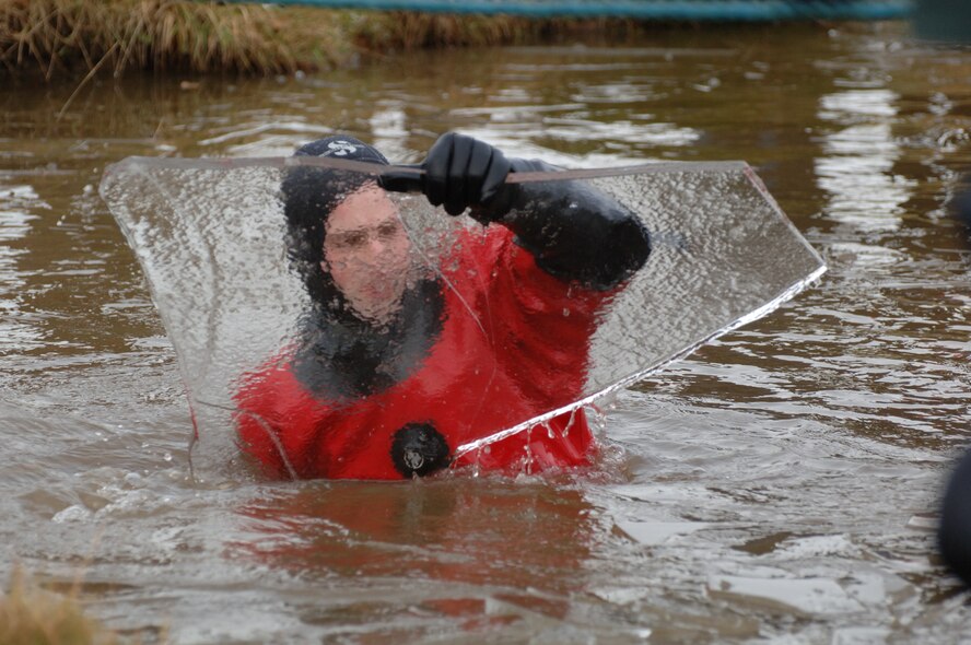 One of the organizers of the event removes some ice from a water obstacle the JAC Hammers cross during the Tough Guy Challenge near Birmingham, England.   (Photo by Bridget Cruz)