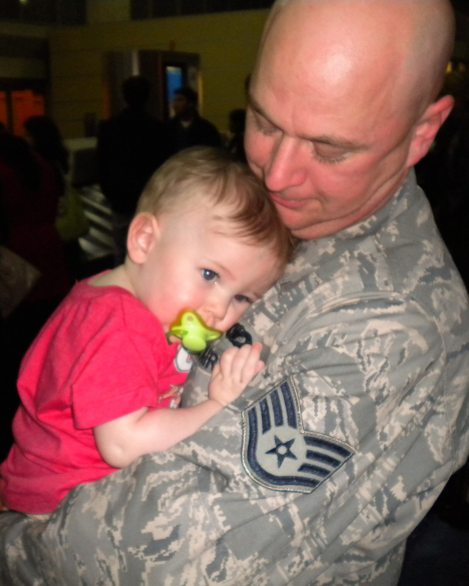 Staff Sgt. Michael Hall, 442nd Security Forces Squadron, holds his daughter after his return from a six-month deployment to Iraq. Sergeant Hall, along with 13 other Security Forces Airmen returned to Kansas City International Airport in January. The 442nd SFS is part of the 442nd Fighter Wing, an Air Force Reserve unit at Whiteman Air Force Base, Mo.                     