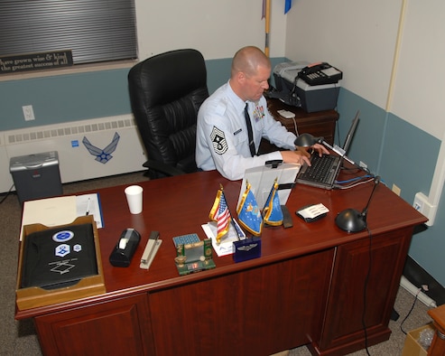 Command Chief Master Sergeant (CCMSgt) William McGovern, 143d Airlift Wing (AW), settles into his new office in building P-1, Quonset Air National Guard Base (ANGB). CCMSgt McGovern was appointed as the fourth Wing Command Chief for the 143d AW at a ceremony held during the September 2009 Unit Training Assembly (UTA). USAF photo by Technical Sergeant Jason Long (Released)