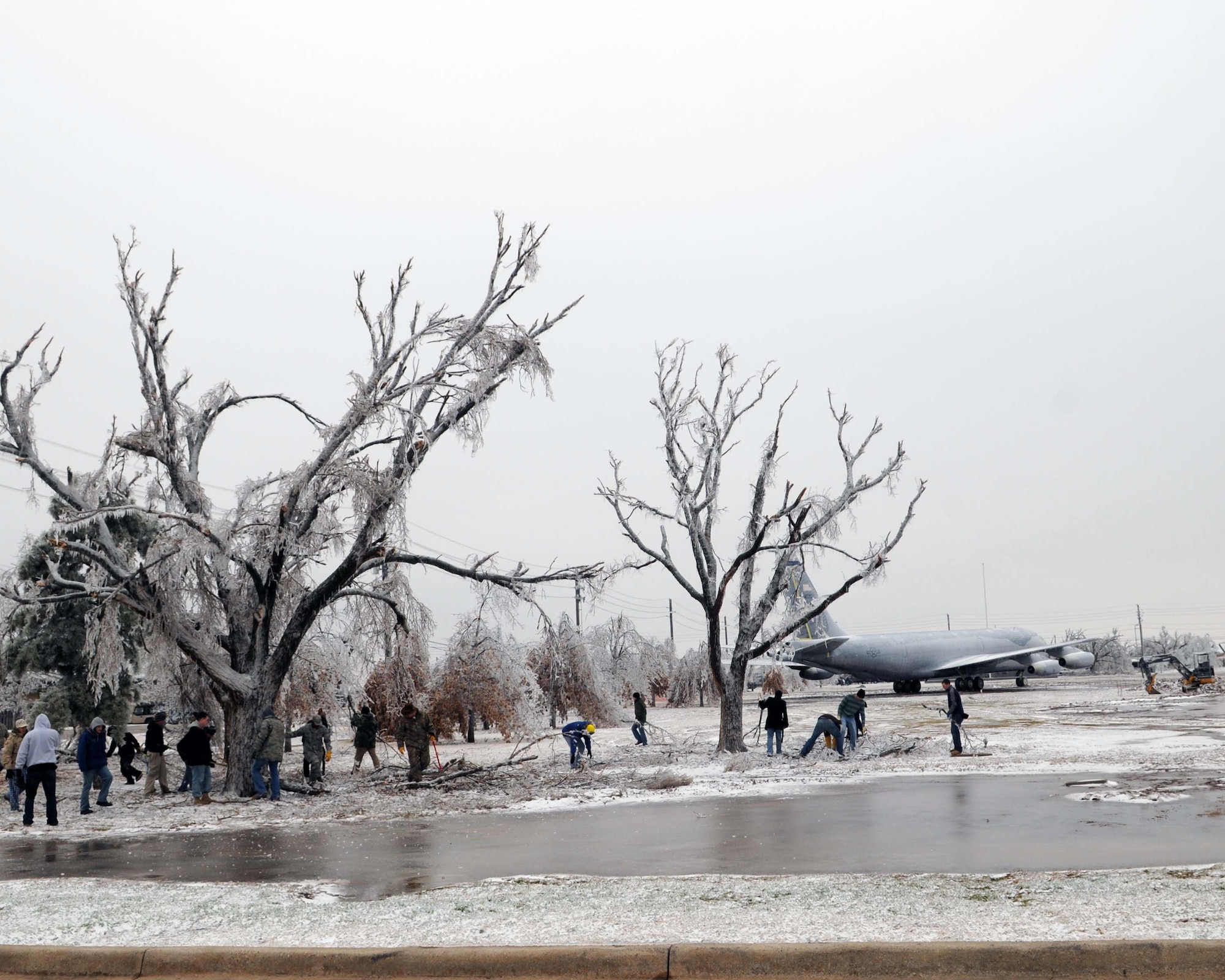 ALTUS AIR FORCE BASE, Okla. -- 97th Air Mobility Wing volunteers work to clean up the fallen tree limbs at the Wings of Freedom Park Jan. 30. Due to an ice storm that hit Altus Jan. 28, power outages and debris covered much of the base and town. (U.S. Air Force photo/Senior Airman Leandra D. Hernandez)