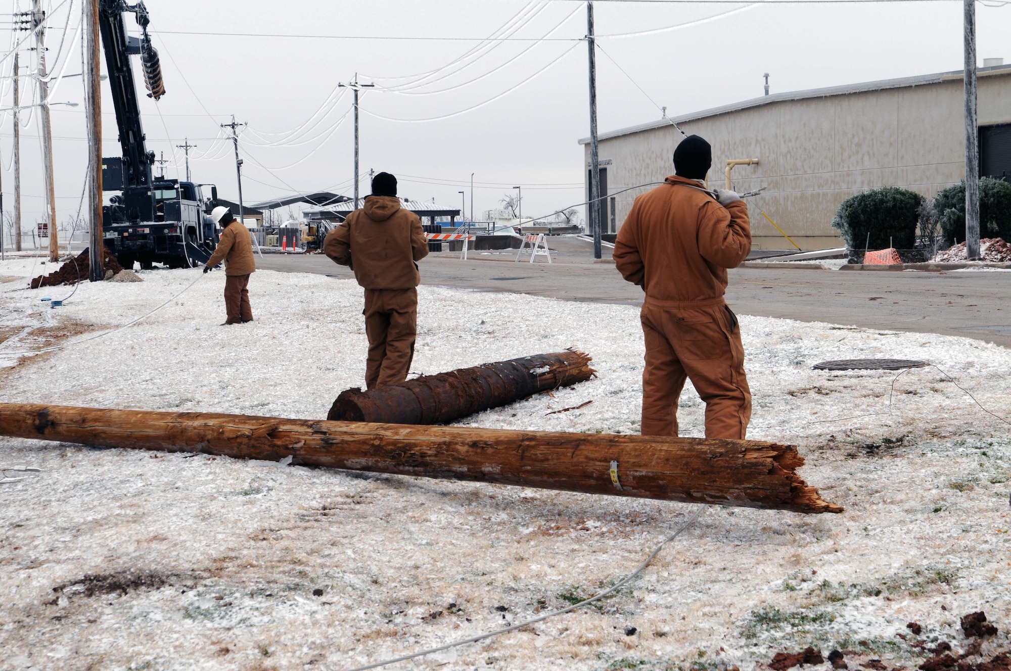 ALTUS AIR FORCE BASE, Okla. -- Electricians from the 97th Civil Engineering Squadron work on the downed power lines Jan. 30. An ice storm hit Altus Jan. 28 causing a power outage for more than 30,000 people in the Altus area. Airmen from Dyess and Lackland AFB, Texas, came to assist Altus with downed power lines. (U.S. Air Force photo/Senior Airman Leandra D. Hernandez)