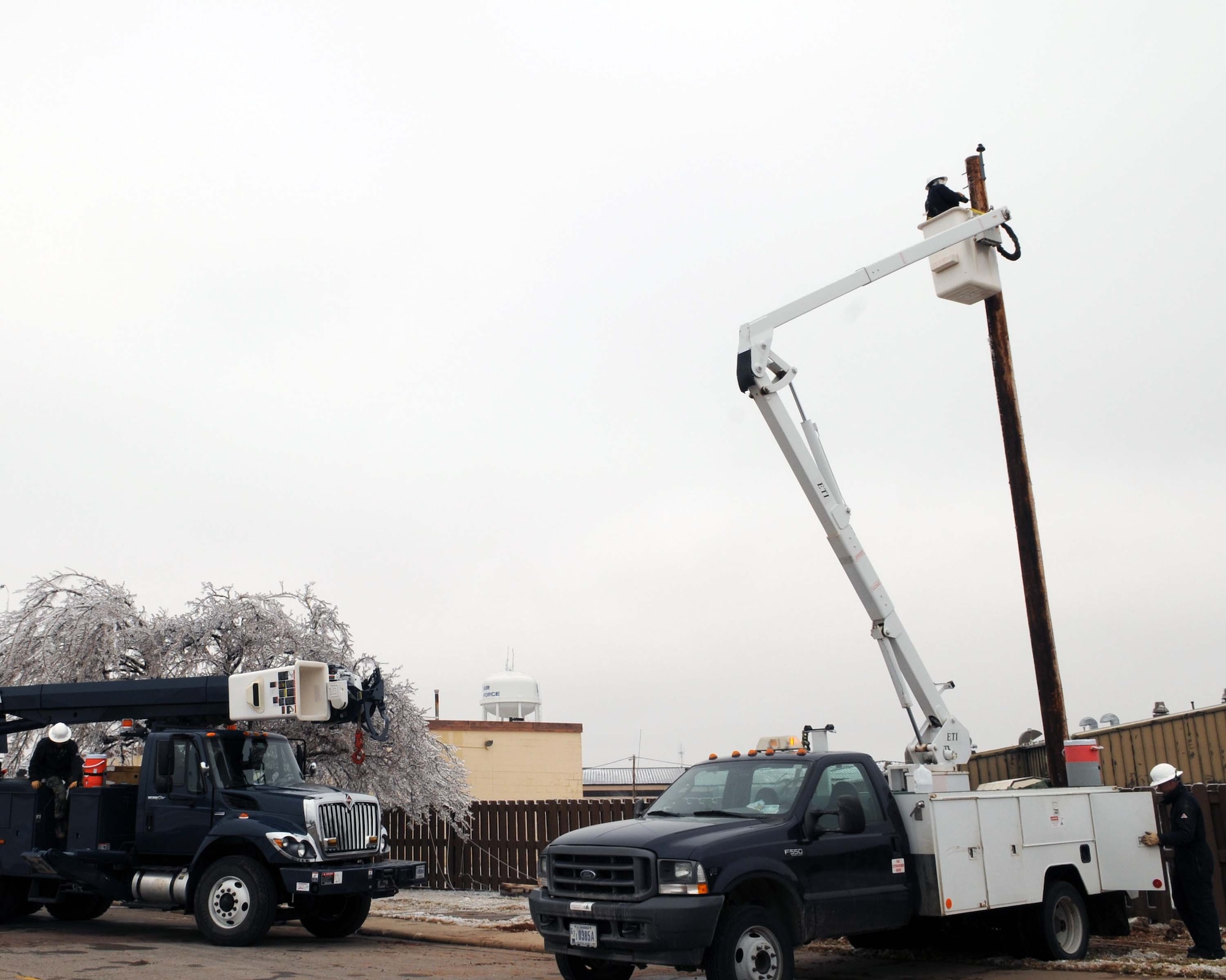 ALTUS AIR FORCE BASE, Okla. -- Members of the 7th Civil Engineering Squadron from Dyess AFB, Texas, work on power lines to bring power back to Altus AFB. Airmen from Dyess and Lackland AFB, Texas, came to assist Altus with the power outage that was caused by an ice storm that hit Jan. 28. (U.S. Air Force photo/Senior Airman Leandra D. Hernandez)