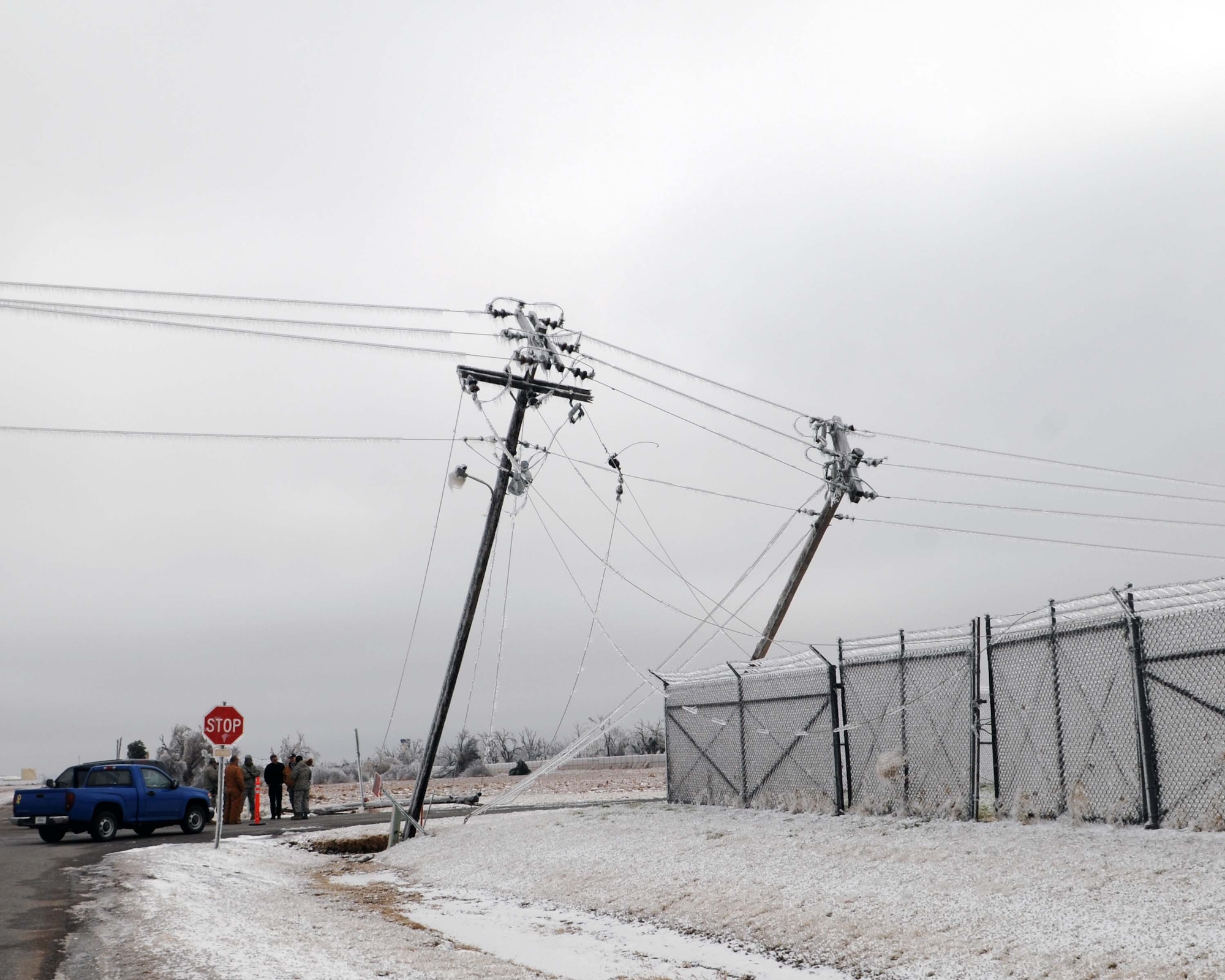 ALTUS AIR FORCE BASE, Okla. -- 97th Air Mobility Wing emergency management personnel talk with Dan Scott, Representative of the City of Altus power and Mike Hagy, Representative of Southwest Rural Electric to discuss the down power lines outside of the Jasmine gate Jan. 30. An ice storm that hit Jan. 28 left more than 30,000 people without power around the Altus area. (U.S. Air Force photo/ Senior Airman Leandra D. Hernandez)