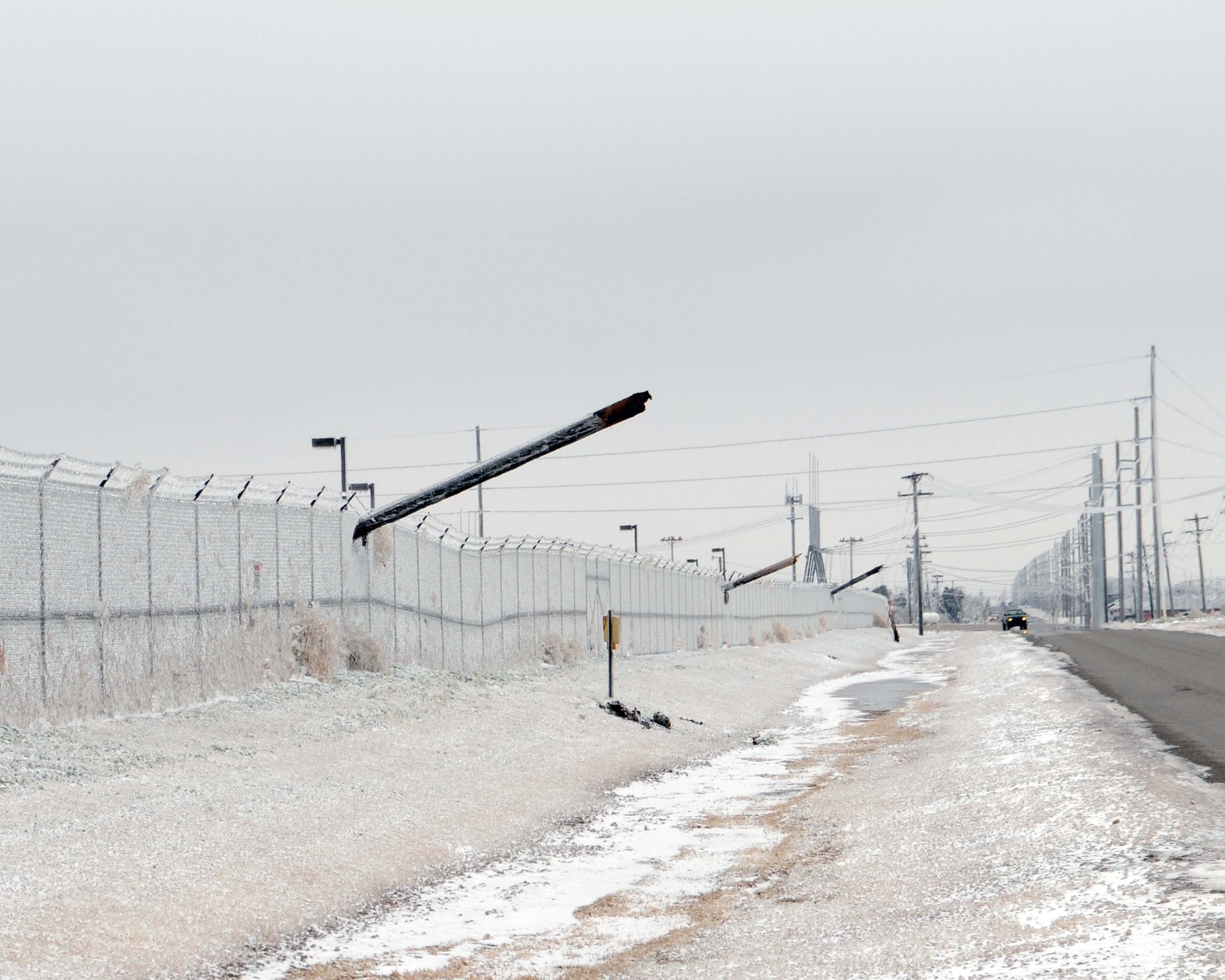 ALTUS AIR FORCE BASE, Okla. -- Power line poles broke outside of Altus AFB during an ice storm that hit Jan. 28 causing power outages for more than 150,000 people in the southwest Oklahoma region. The city of Altus power representatives, Southwest Rural Electric representatives as well as members of the 97th Civil Engineering Squadron are working together to resolve the power outage. (U.S. Air Force photo/Senior Airman Leandra D. Hernandez)