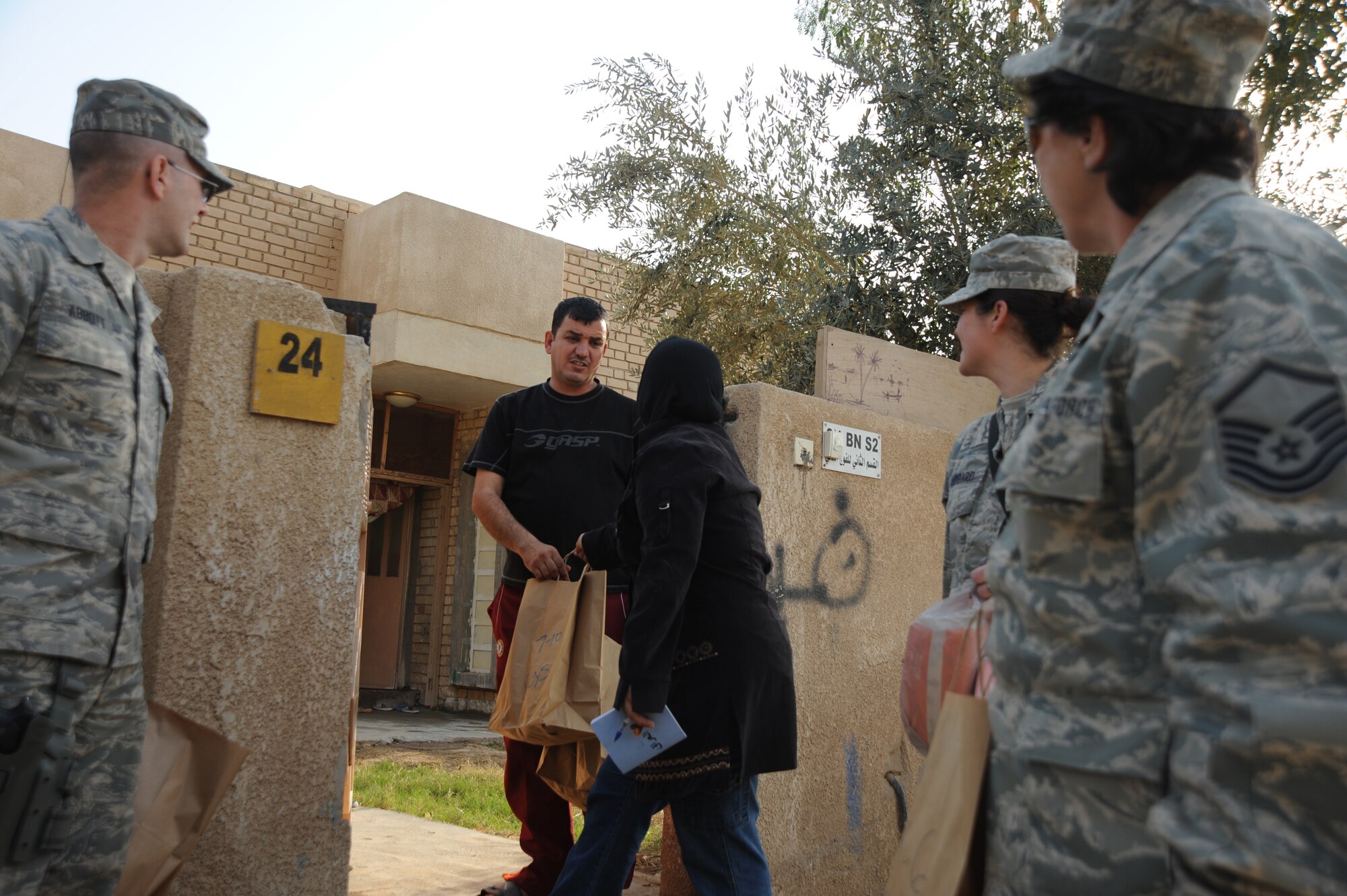Airman from Sather Air Base hand out bags of donated goods to Iraqis living in Area Four as part of the Good Neighbor Program Jan. 29, 2010. The GNP collects donated goods and distributes them throughout the Iraqi community.  (U.S. Air Force photo/ Senior Airman Eric Summers Jr/ released)