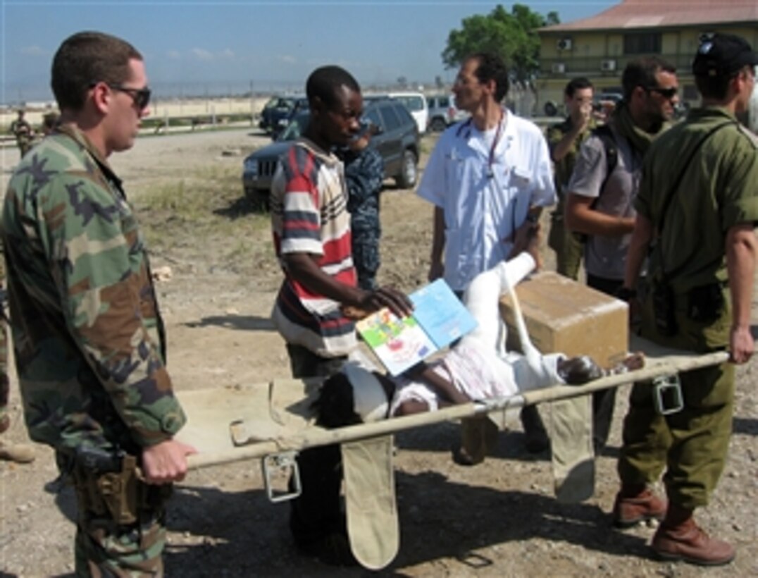 A U.S. Navy sailor and an Israeli soldier carry a Haitian girl to a waiting helicopter near Port-au-Prince, Haiti, on Jan. 25, 2010.  The helicopters transport the patients to Navy ships anchored off the coast of Port-au-Prince for treatment.  