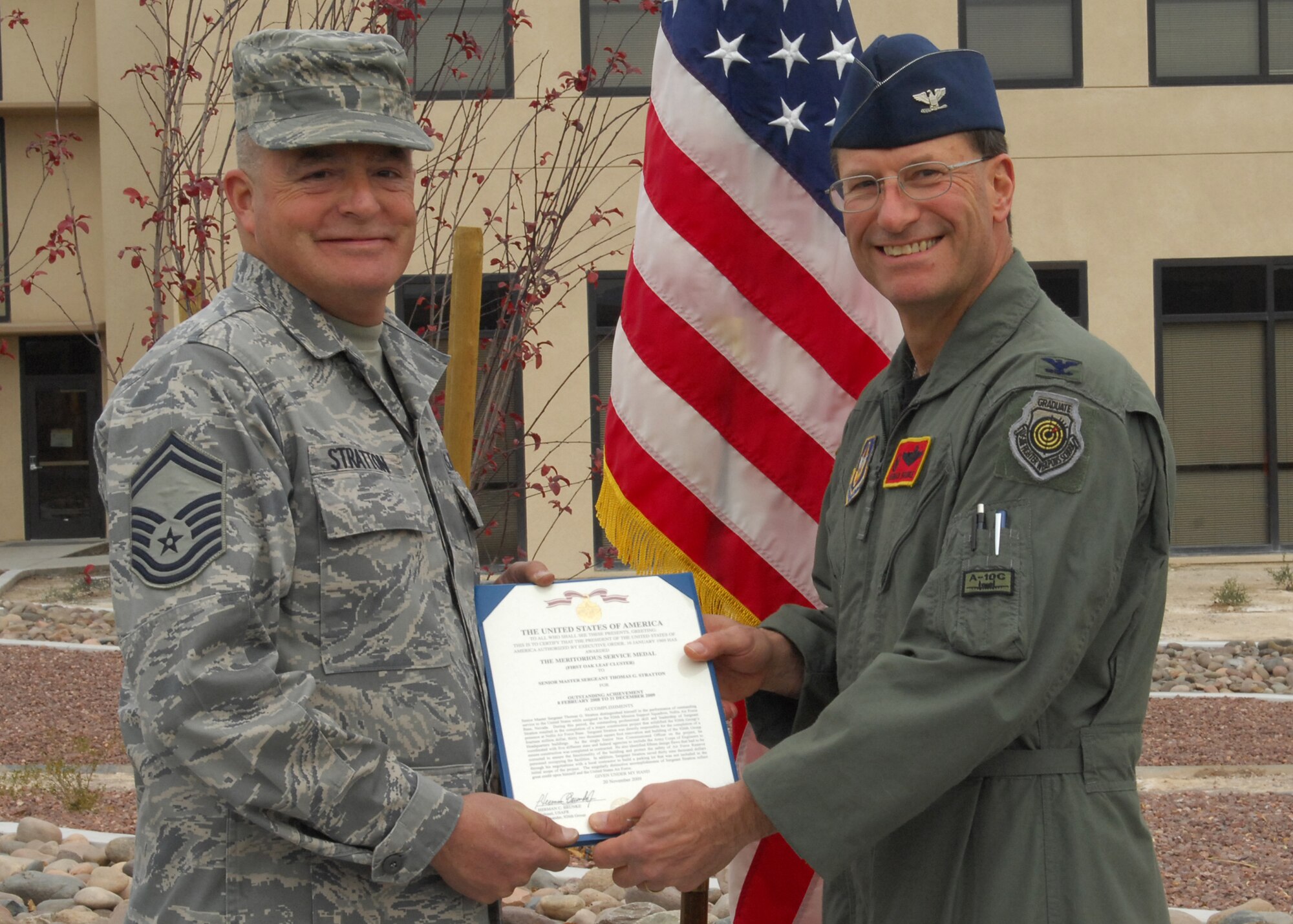 Col. Herman Brunke, 926th Group commander (right), presents Senior Master Sgt. Thomas Stratton, 926th Mission Support Squadron supply management superintendent, with a meritorious service medal during the group's building ribbon cutting ceremony Jan. 8. As the group's building custodian, Sergeant Stratton was instrumental to the $14.5 million renovation project. (U.S. Air Force photo/Staff Sgt. Erin Worley)