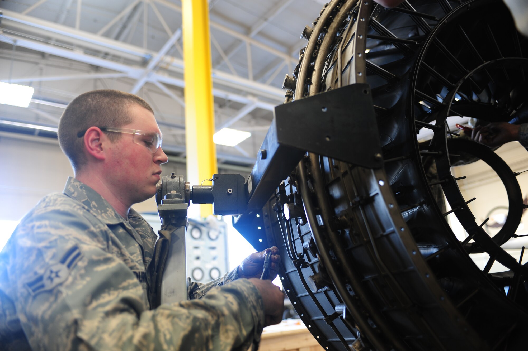 ELLSWORTH AIR FORCE BASE, S.D. -- Airmen 1st Class Steven Durr, 28th Maintenance Squadron aerospace propulsion maintenance apprentice, removes the safety wire on the augmenter flame holder from a B-1B Lancer engine, Feb 3.  While working with safety wire, Airman Durr ensured his eyes were protected by utilizing the proper protective equipment. (U.S Air Force photo/Airman 1st Class Anthony Sanchelli)
