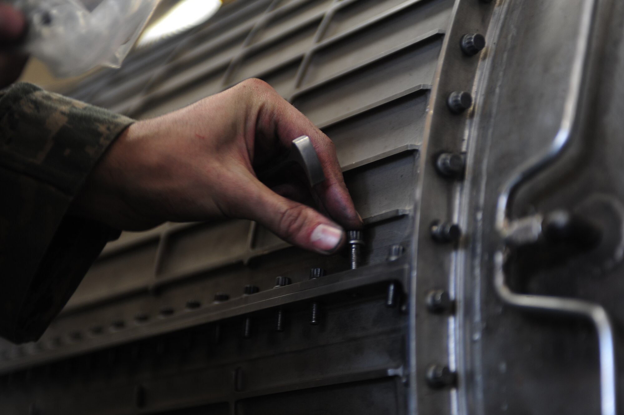 ELLSWORTH AIR FORCE BASE, S.D. -- Airman 1st Class Justin Hildreth, 28th Maintenance Squadron aerospace propulsion maintenance apprentice, places bolts in the upper-outer fan duct of a B-1B Lancer engine, Feb 3.  Carrying the largest payload of both guided and unguided weapons in the Air Force inventory, the multi-mission B-1 is the backbone of America's long-range bomber force. (U.S Air Force photo/Airman 1st Class Anthony Sanchelli)