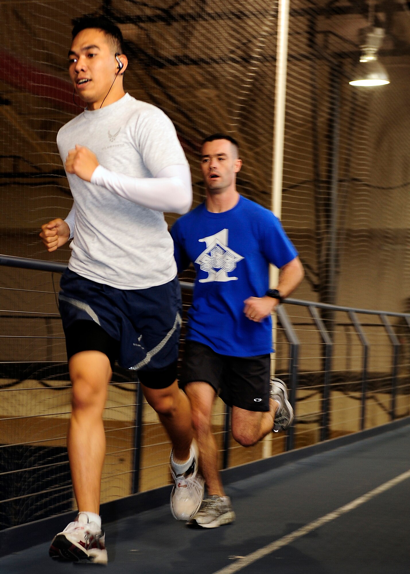 HOLLOMAN AIR FORCE BASE, N.M. -- Senior Airman Darryl Supetran, 49th Logistic Readiness Squadron, and Master Sgt. Dave Kalal, 49th Communications Squadron, run on the indoor track at the Domenici Fitness and Sports Center during the Iron Airman competition, Jan. 29. Three teams competed in each event for the title of "Iron Airman." (U.S. Air Force photo by Senior Airman DeAndre Curtiss)