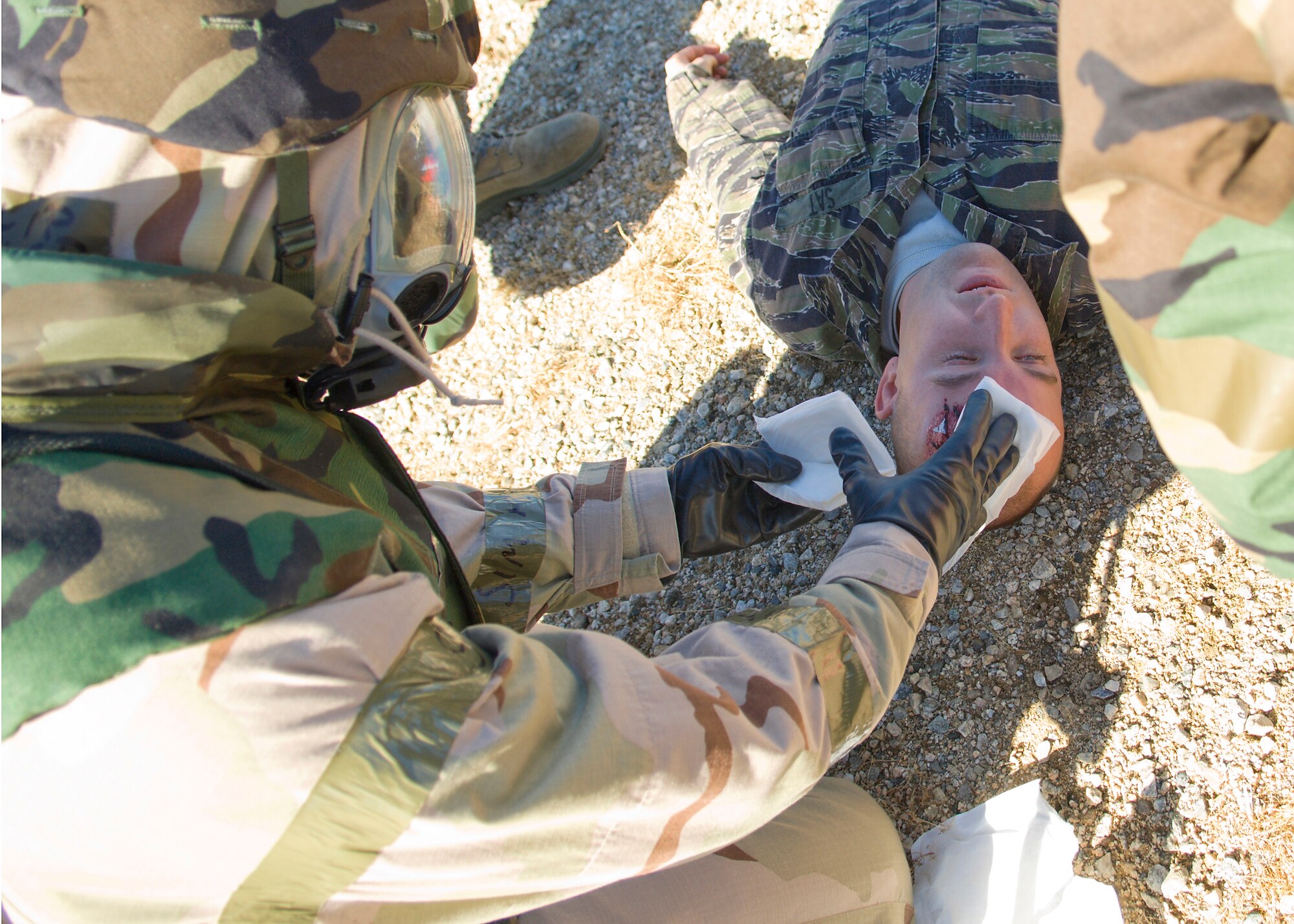 An Edwards Airman performs self-aid buddy care on an injured "victim" during Phase II of the base's Operational Readiness Exercise Jan. 28. Phase II of the exercise aims to test Airmen on self-aid buddy care, weapons familiarization, post-attack recognizance and general knowledge of Air Force Manual 10-100. (Air Force photo/Mike Cassidy)