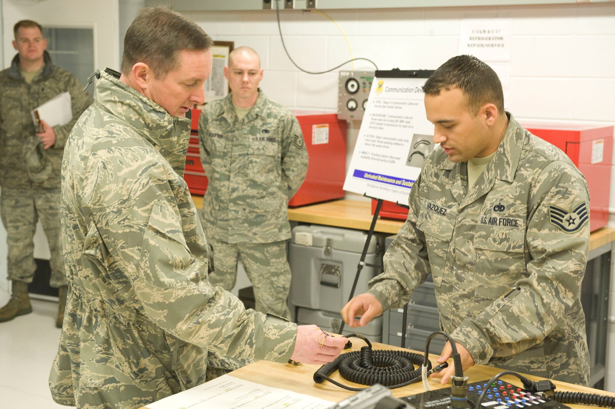 (Right) Staff Sgt. Brandon Vazquez, 436th Maintenance Squadron, demonstrates communications equipment for Col. Stephen Clark, Installation Excellence Selection Board member, Feb. 2. Sergeant Vazquez showed the process of recovering communication equipment instead of having it thrown away, saving $250,000 bi-annually. (U.S. Air Force photo/John Sidoriak)