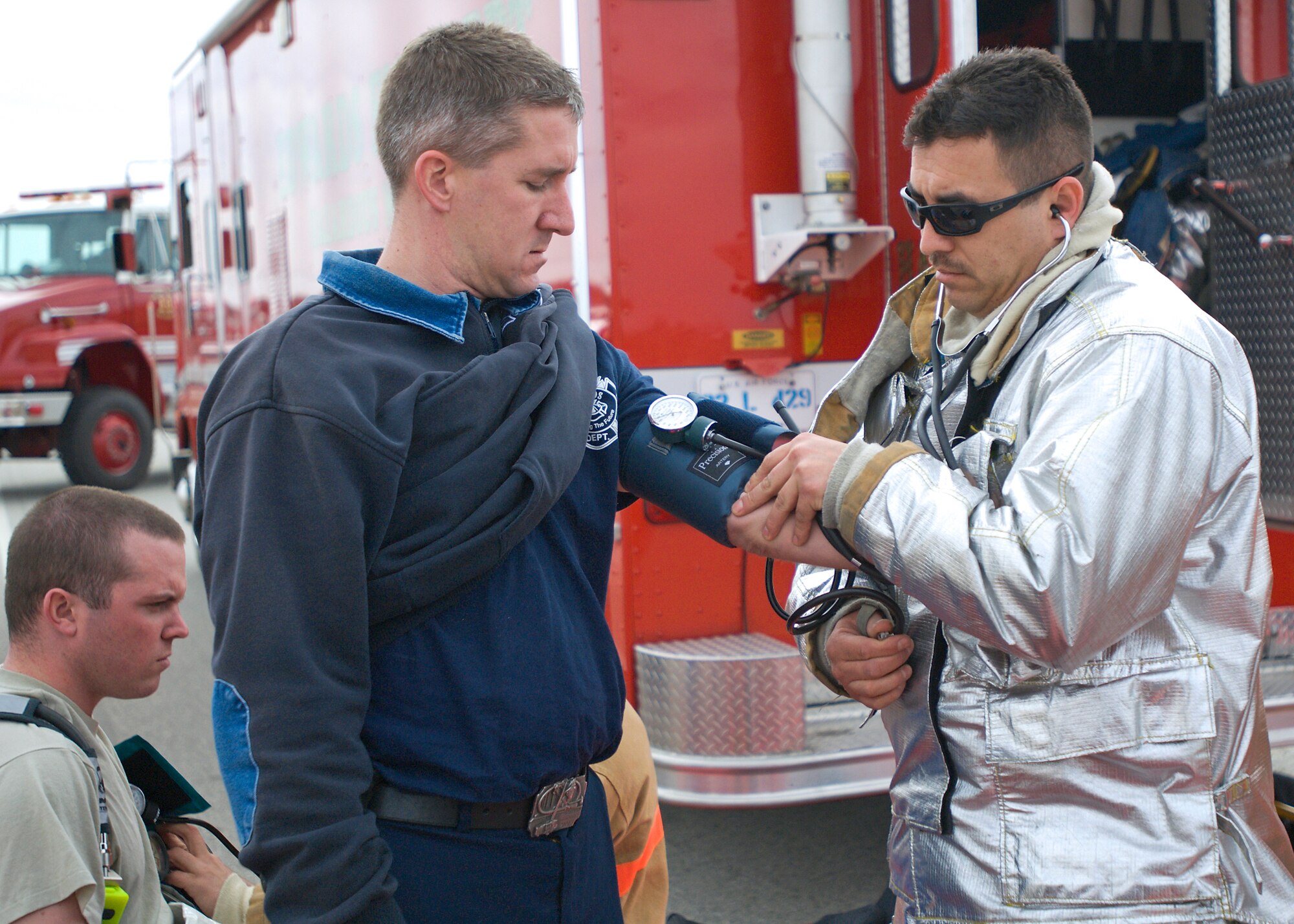 Freddie Yanez (right), Edwards Fire Department lead firefighter, checks the vitals of Daniel Roy, base firefighter, following participation in a hazardous chemical spill exercise Jan. 26. Roads were blocked as part of the response and 19 buildings were evaluated. (Air Force photo/Heather Anhalt)