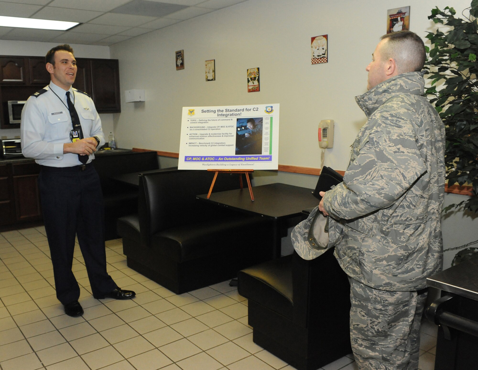 (Left) Capt. Patrick McClintock, 436th Airlift Wing Command Post, briefs Col. David Ellis, Installation Excellence Selection Board member about the integration of Command Post, Maintenance Operations Center and Air Terminal Operations Center into one facility and enhanced mission effectiveness. (U.S. Air Force photo/Brianne Zimny)