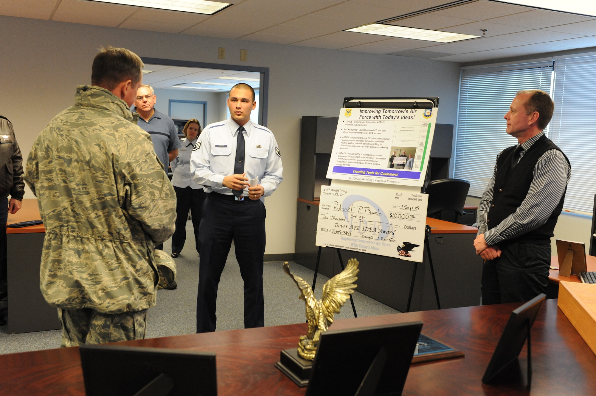 (Center) Staff Sgt. Philip Johnson, 436th Force Support Squadron, briefs Col. Stephen Clark, Installation Excellence Selection Board member, Feb. 1. His briefing covered the subject of improving tomorrow?s Air Force with today?s ideas, using tools like Air Force Smart Operations for the 21st Century and the IDEA program. These tools helped save Dover Air Force Base approximately $1.5 million in energy costs. (U.S. Air Force photo/Roland Balik)
