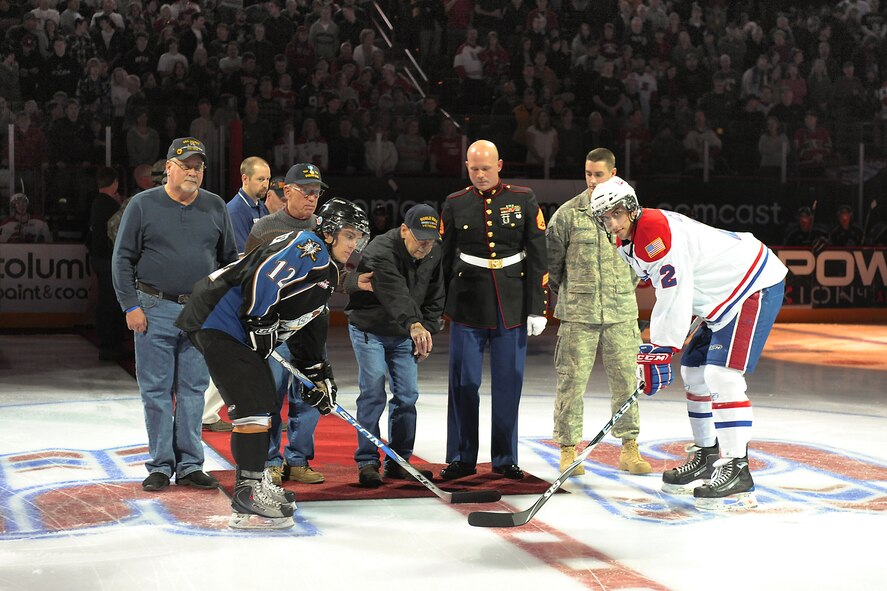 FAIRCHILD AIR FORCE BASE, Wash. - A World War II veteran prepares to drop the ceremonial puck. The servicemembers shown are comprised of veterans and current servicemembers from each U.S. war, beginning with World War II. (U.S. Air Force photo / Senior Airman Joshua Chapman)