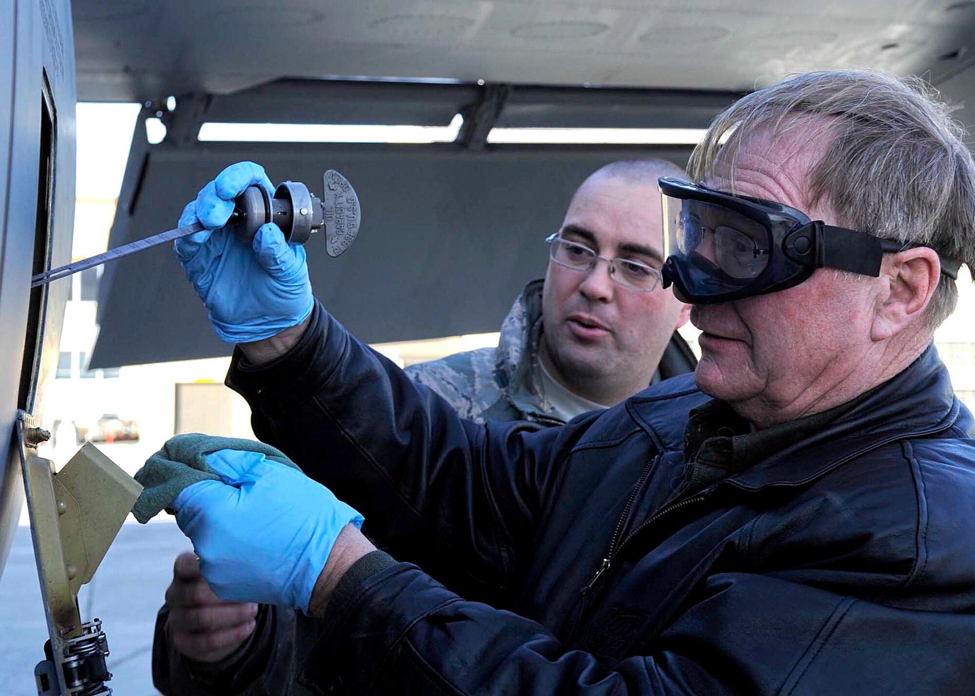 FAIRCHILD AIR FORCE BASE, Wash. - Jerry Newcomb, owner of J&J Lube in Airway Heights, checks the oil in KC-135 Stratotanker during a Honorary Commanders tour here Jan. 22. The tour of Fairchild gives the Honorary Commanders and Eagles an opportunity to explore the base and get a better understanding of military way of life. (U.S. Air Force photo / Senior Airman Darlene West)