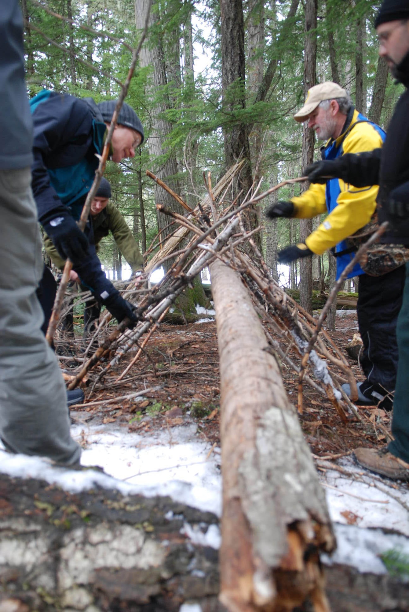 PRIEST LAKE, Idaho - Civilians who attended the training begin creating a natural shelter in the woods near Priest Lake Jan. 30 during a two-day training held by SERE Specialists. (U.S. Air Force photo / Senior Airman Emerald Ralston)