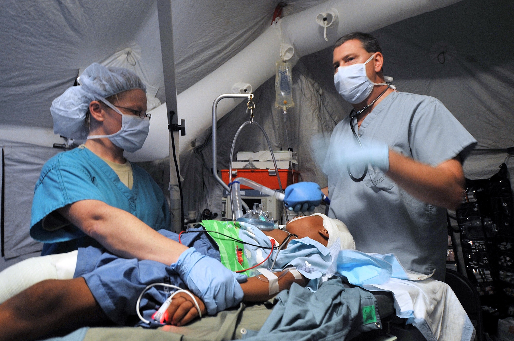 U.S. Air Force Capt. Elberta Carter, an operating room nurse and a member of Joint Task Force Bravo’s medical element, assists Lt. Col. Ken Williams, a nurse anesthetist and member of Joint Task Force Bravo’s medical element, in caring for a five-year old Haitian boy at Haitian Coast Guard base Amiral Killick in Carrefour, Haiti, on Jan. 20, 2010. The boy was treated for a head wound and leg fracture.   DoD photo by Petty Officer 3rd Class Brandyn Hill, U.S. Coast Guard. (Released) 
 