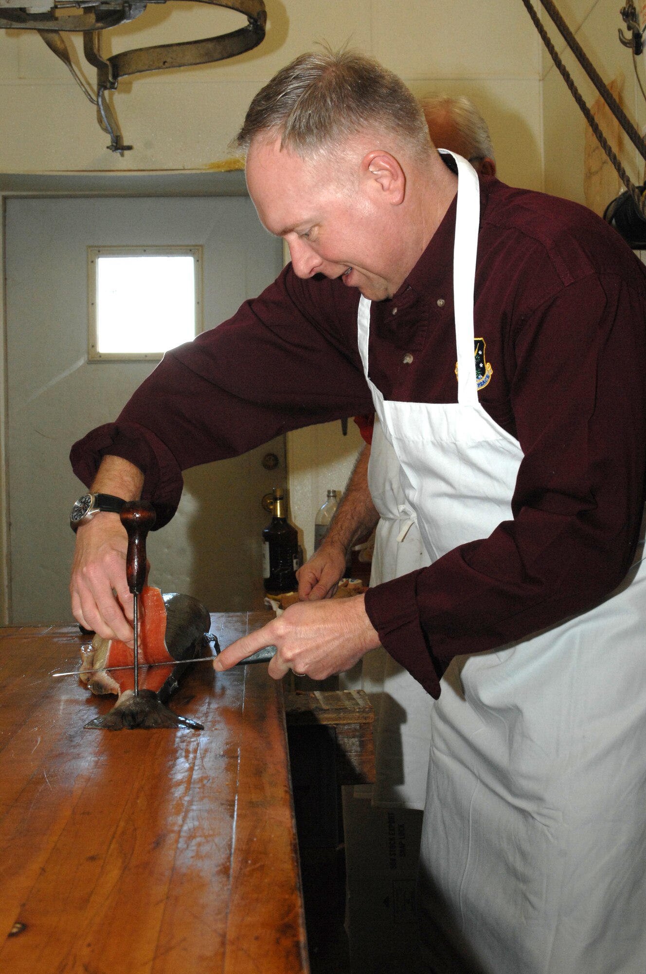 MINOT, N.D. -- Col. Fred Stoss  91st Missile Wing commander, prepares salmon at Blom’s Meat Market here Jan. 29, for the upcoming 45th Annual Sportsmen Feed. The feed, which is an annual event designed to build fellowship between the base and local community, was held at the Jimmy Doolittle Center Jan. 31, at Minot AFB. (U.S. Air Force photo by Airman 1st Class Aaron-Forrest Wainwright)