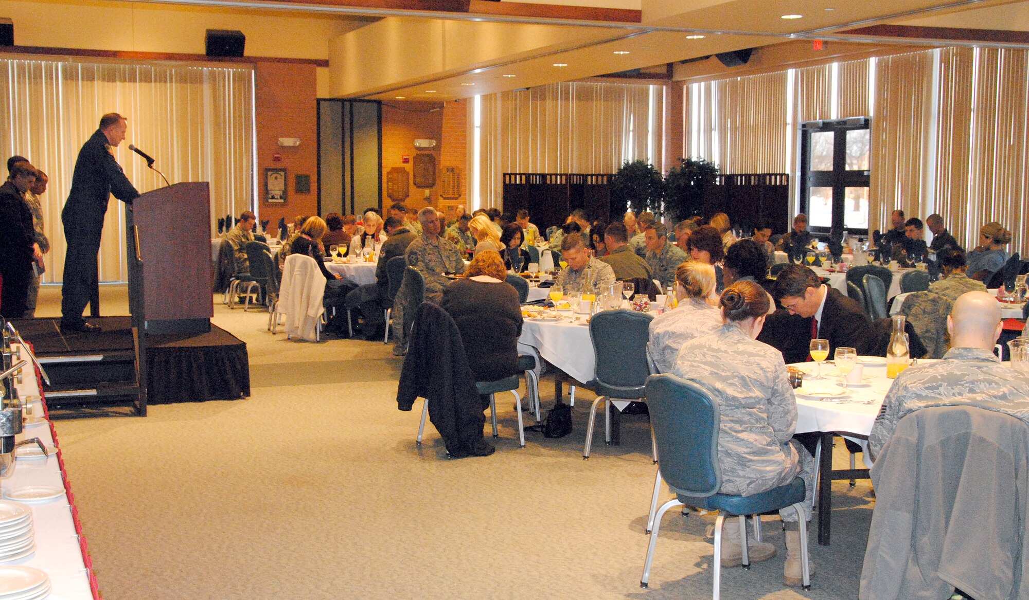 Howard Deunk, far left, the chapel head usher and T-1 simulator operator at Vance AFB, delivers a prayer for the nation during the Commander’s National Prayer Breakfast held Tuesday, Feb. 2, at the Vance Collocated Club. (U.S. Air Force photo/ Joe B. Wiles)