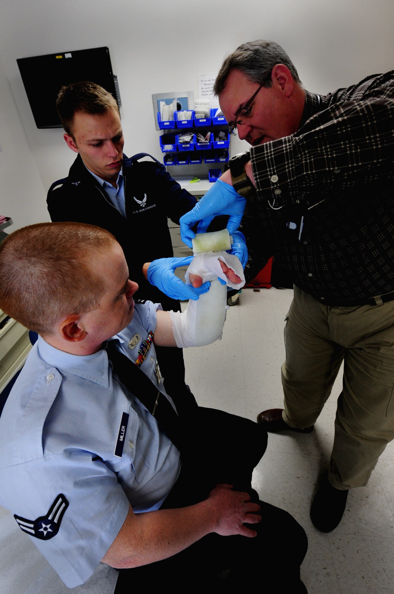 ELLSWORTH AIR FORCE BASE, S.D. -- (Back to front) Airman Albert Thorn, 28th Medical Operations Squadron aerospace medical technician, assists Kevin Wilson, 28 MDOS nurse, apply a temporary cast to the arm of Airman 1st Class Christopher Miller, 28th Security Forces Squadron, Feb. 1, 2010. The 28 MDOS treats a wide variety of medical issues ranging from sickness, injuries, and dental. (U.S. Air Force photo/Airman 1st Class Joshua J. Seybert)