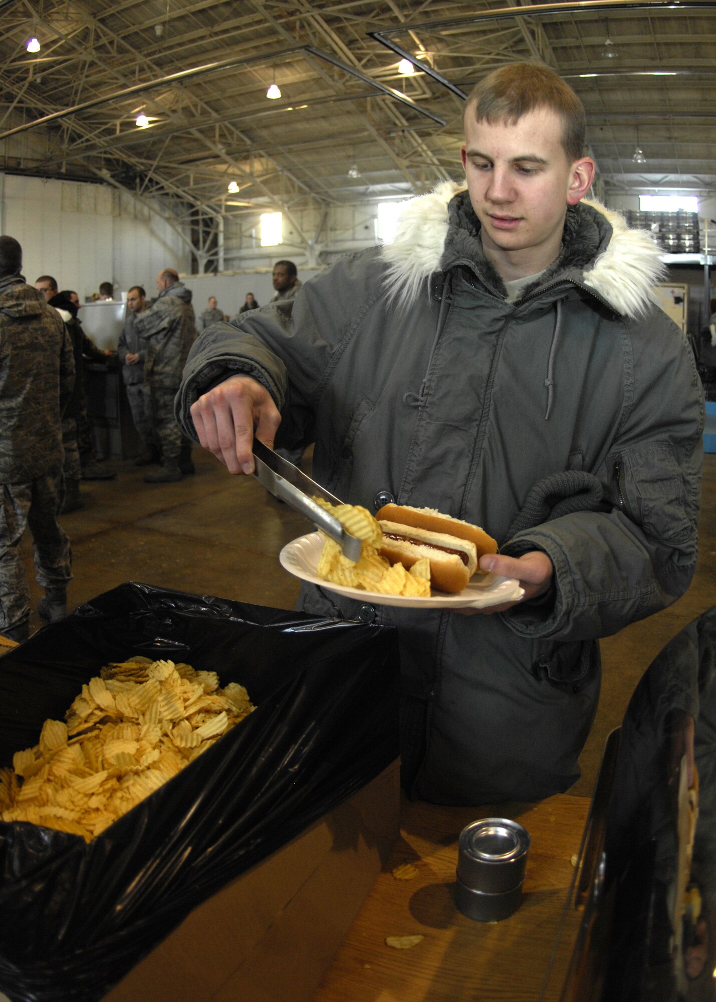 MINOT AIR FORCE BASE, N.D. -- Airman 1st Class Anthony Rosa, 5th Logistics Readiness Squadron vehicle operator, makes a plate of food at a burger burn here Jan. 29. Airmen of the 5th Bomb Wing came together to have lunch and attend an all call to conclude the successful completion of the recent limited nuclear surety inspection. (U.S. Air Force photo by Airman 1st Class Ashley N. Avecilla)