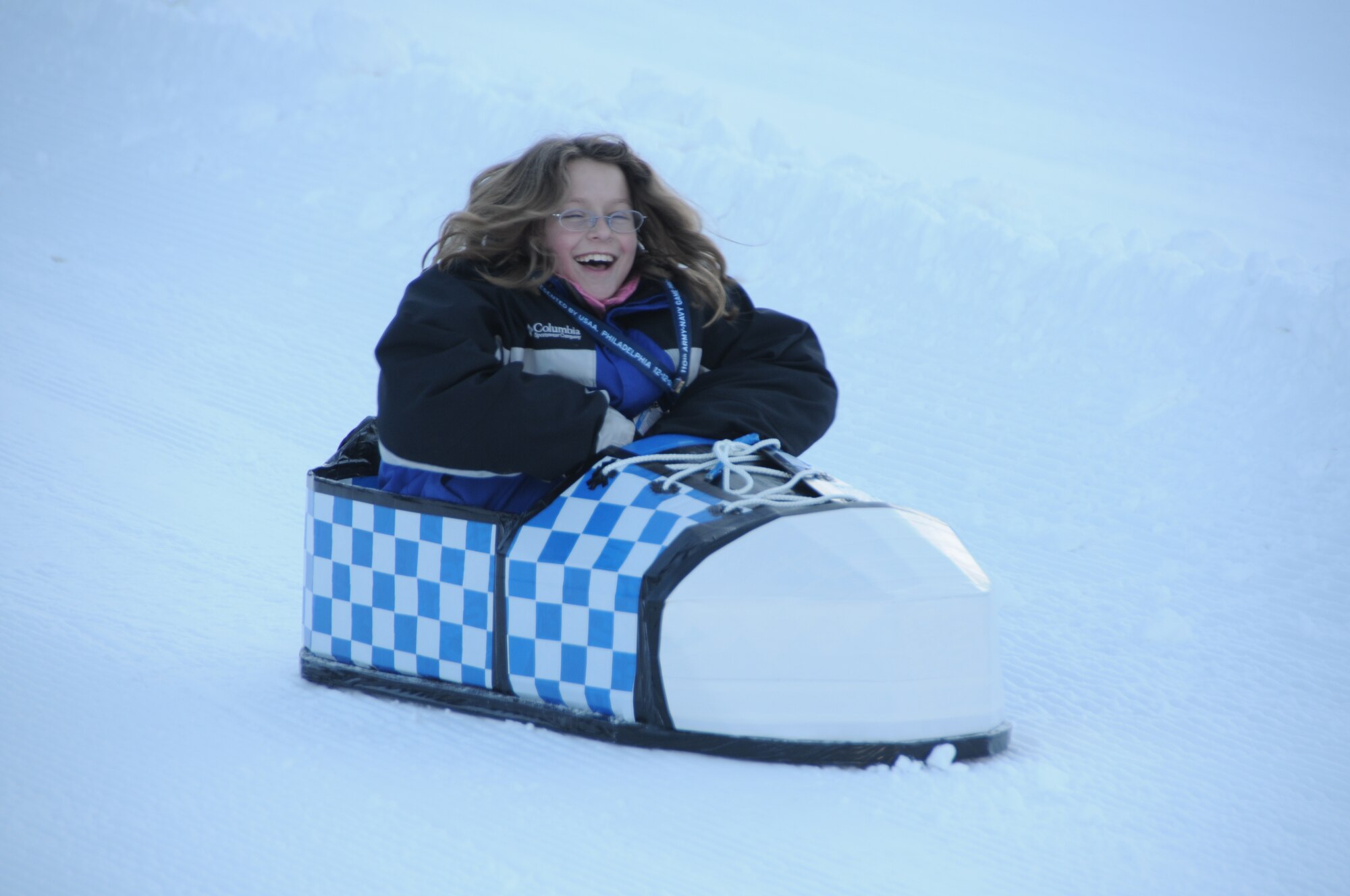 KEYSTONE, Colo. - Sarah Schuh, 10, races down the hill in her "Schuh Flyer", during the cardboard derby race at SnoFest Jan. 30. The three-day event was hosted by Force Support Squadrons from the Air Force Academy, Buckley, F.E. Warren, Peterson and Schriever Air Force Bases. Sarah is the daughter of Maj. Kurt Schuh, Air Reserve Personnel Center. (Courtesy photo)